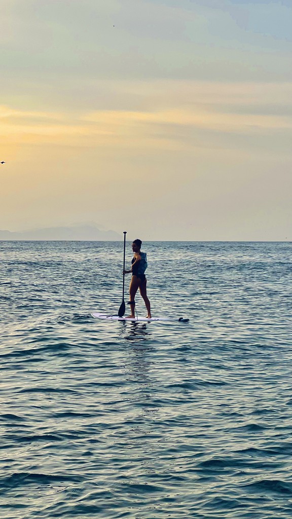 A man stading with Surfboard