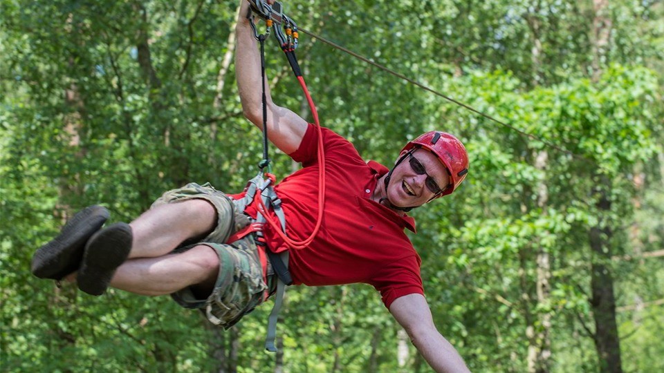 Close-up of a dark green leaf showing its textured surface and central vein against a muted background.