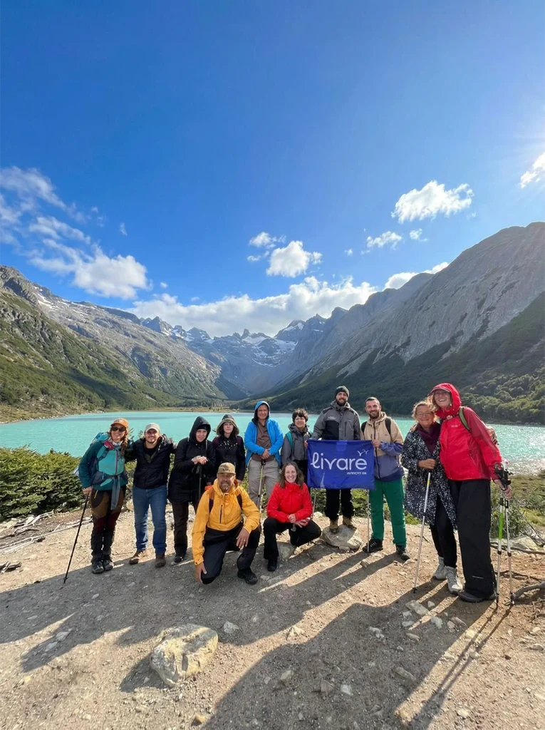 Grupo de viajantes da Livare posando na Montanha das Sete Cores, em Purmamarca, com formações rochosas coloridas ao fundo