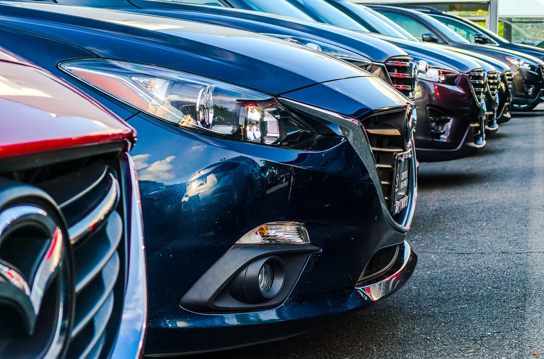 Row of rental cars parked side by side, representing a typical car rental fleet.