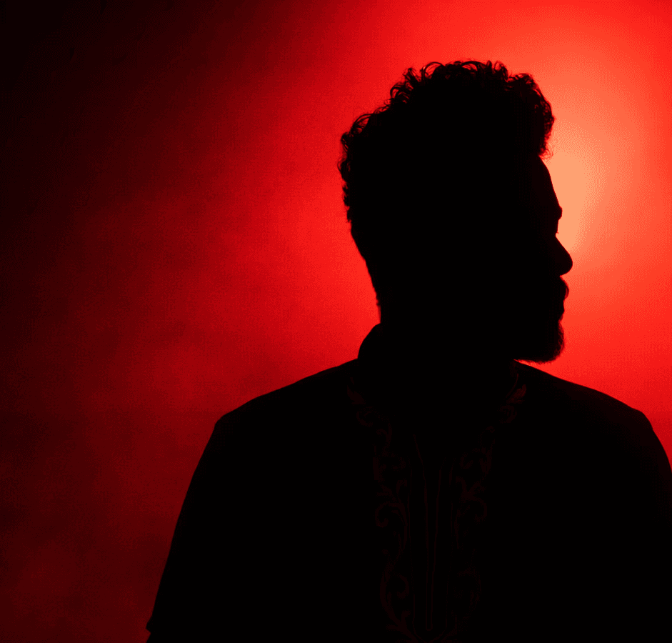 Man's silhouetted profile on red and black background