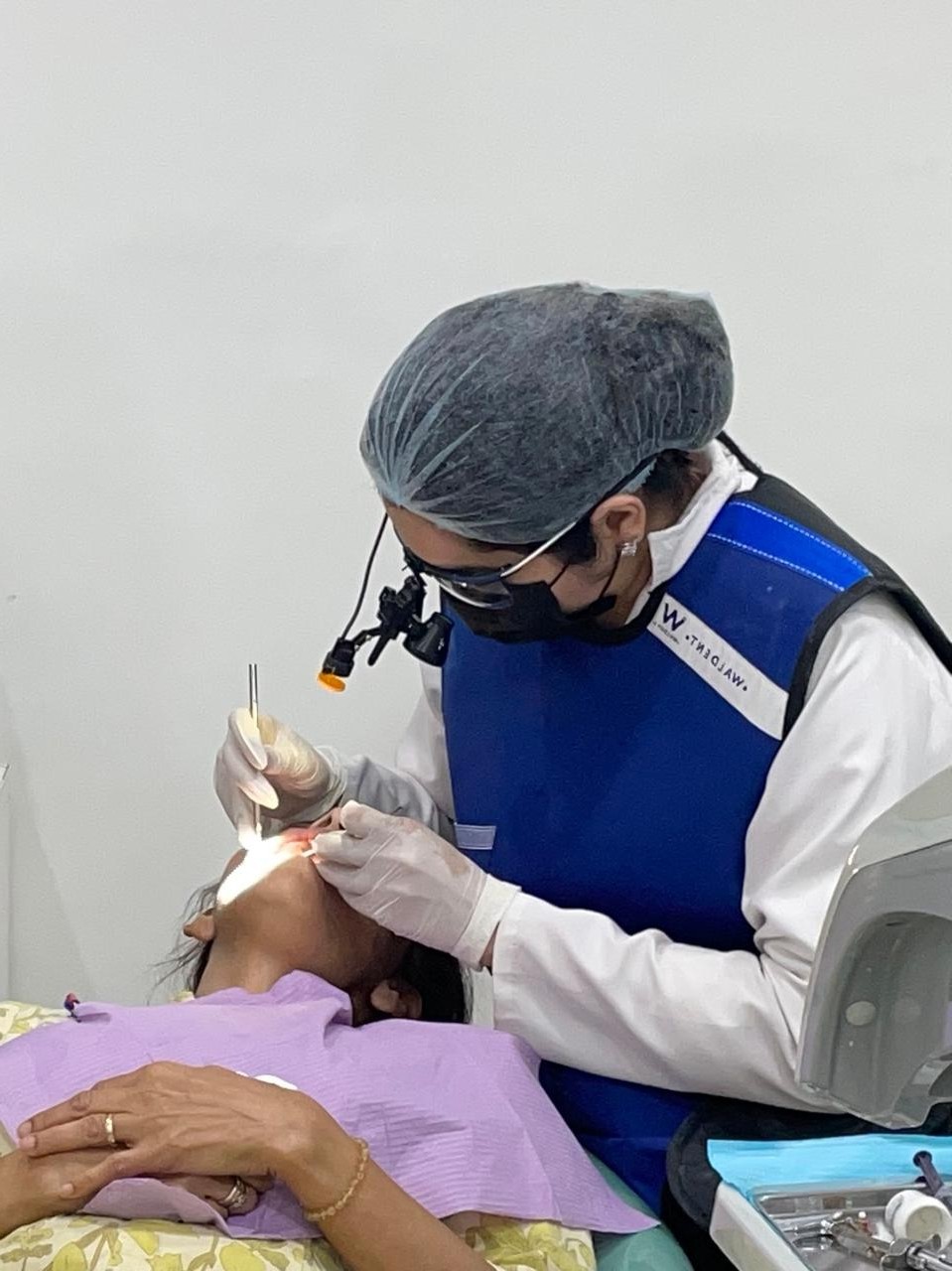 doctor wearing a dental loupe, doing a procedure