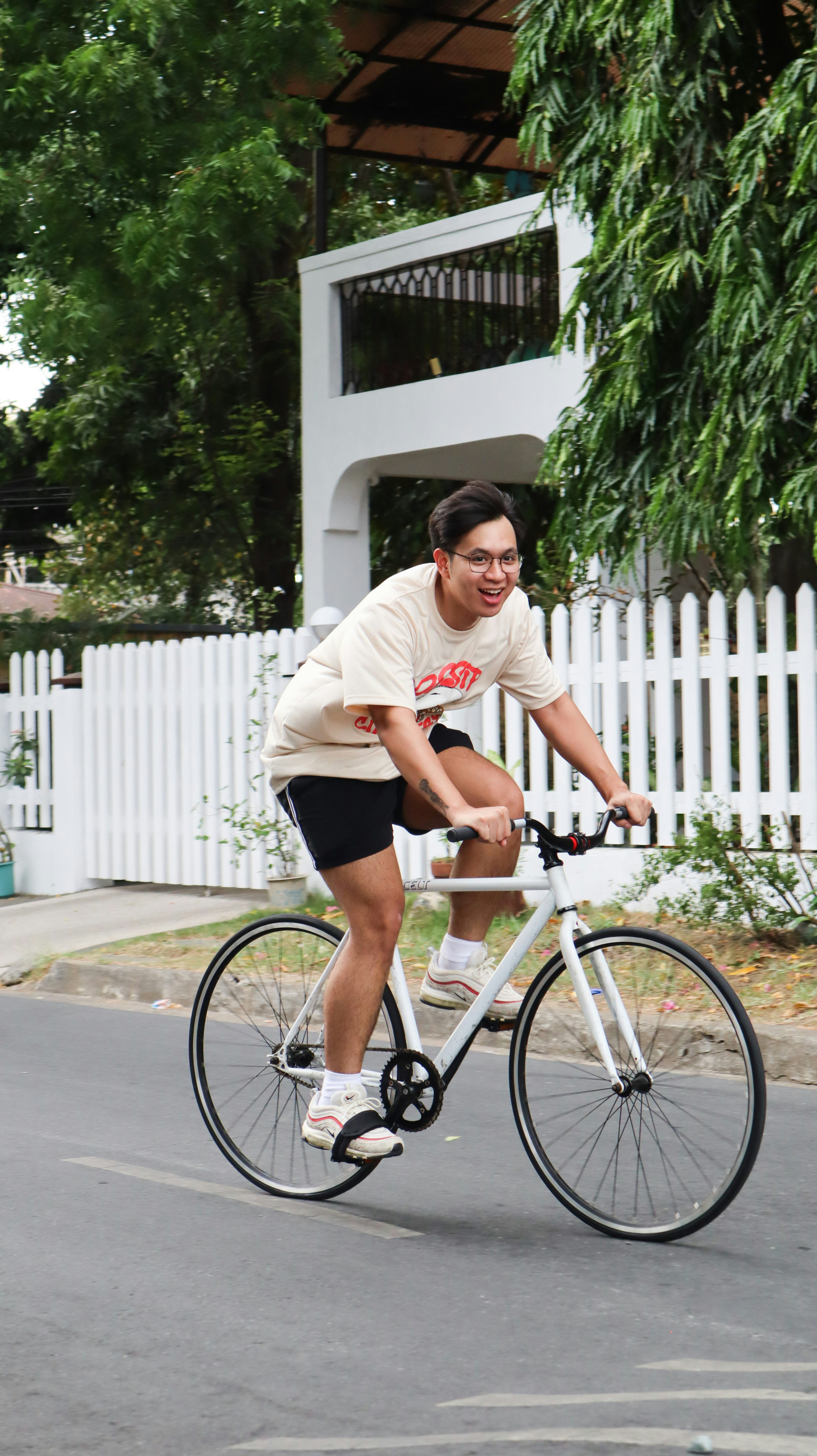 woman in white crew neck t-shirt and black shorts riding on white and black city