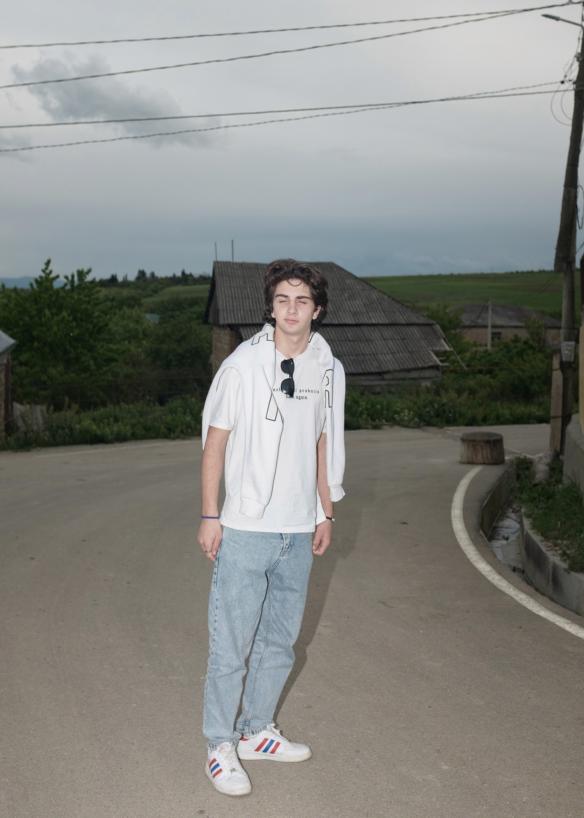 Portrait of Giorgi standing on an empty road in a village near the occupation line