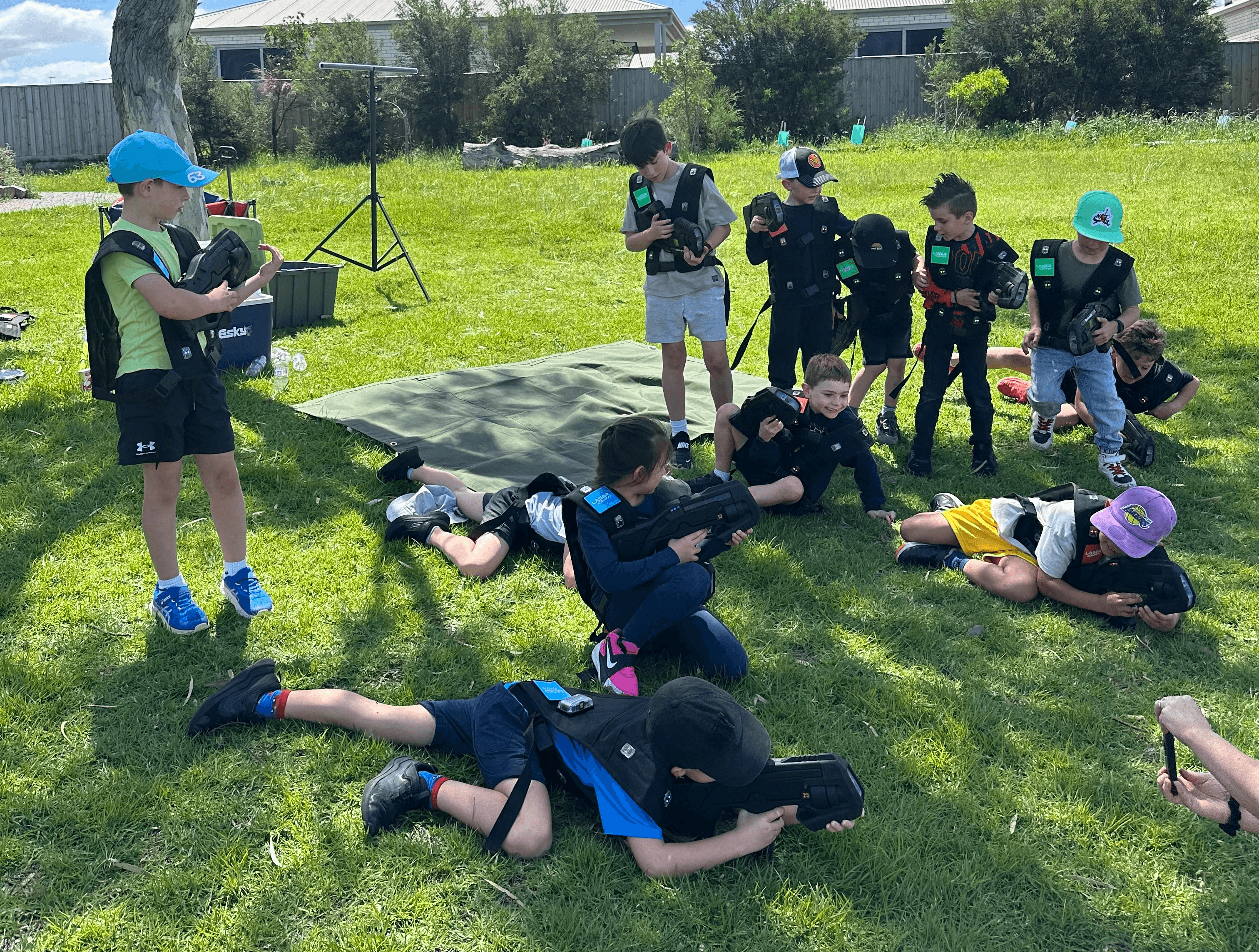Group of children and teenagers playing outdoor laser tag in a Melbourne park.