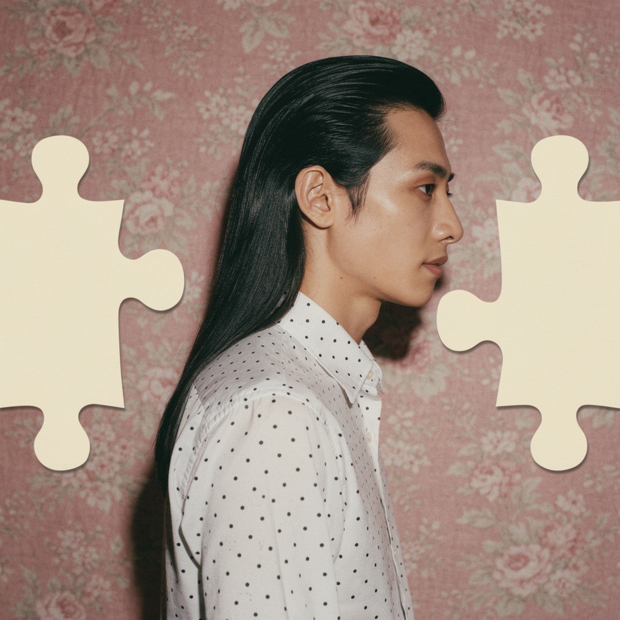 A person with long dark hair in a polka-dot shirt stands against a floral pink background. White puzzle pieces are layered artistically over the image.