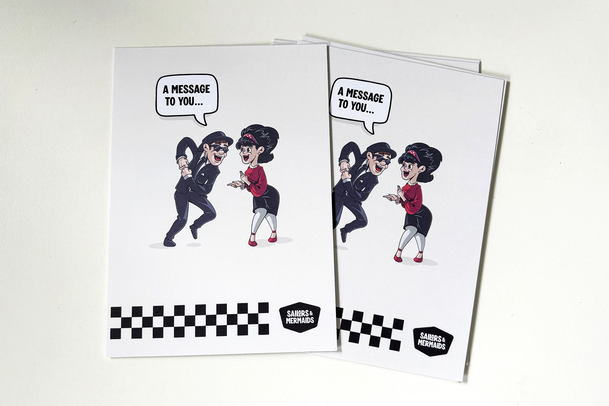 Message cards on a white table. The cards feature two illustrated dancers.