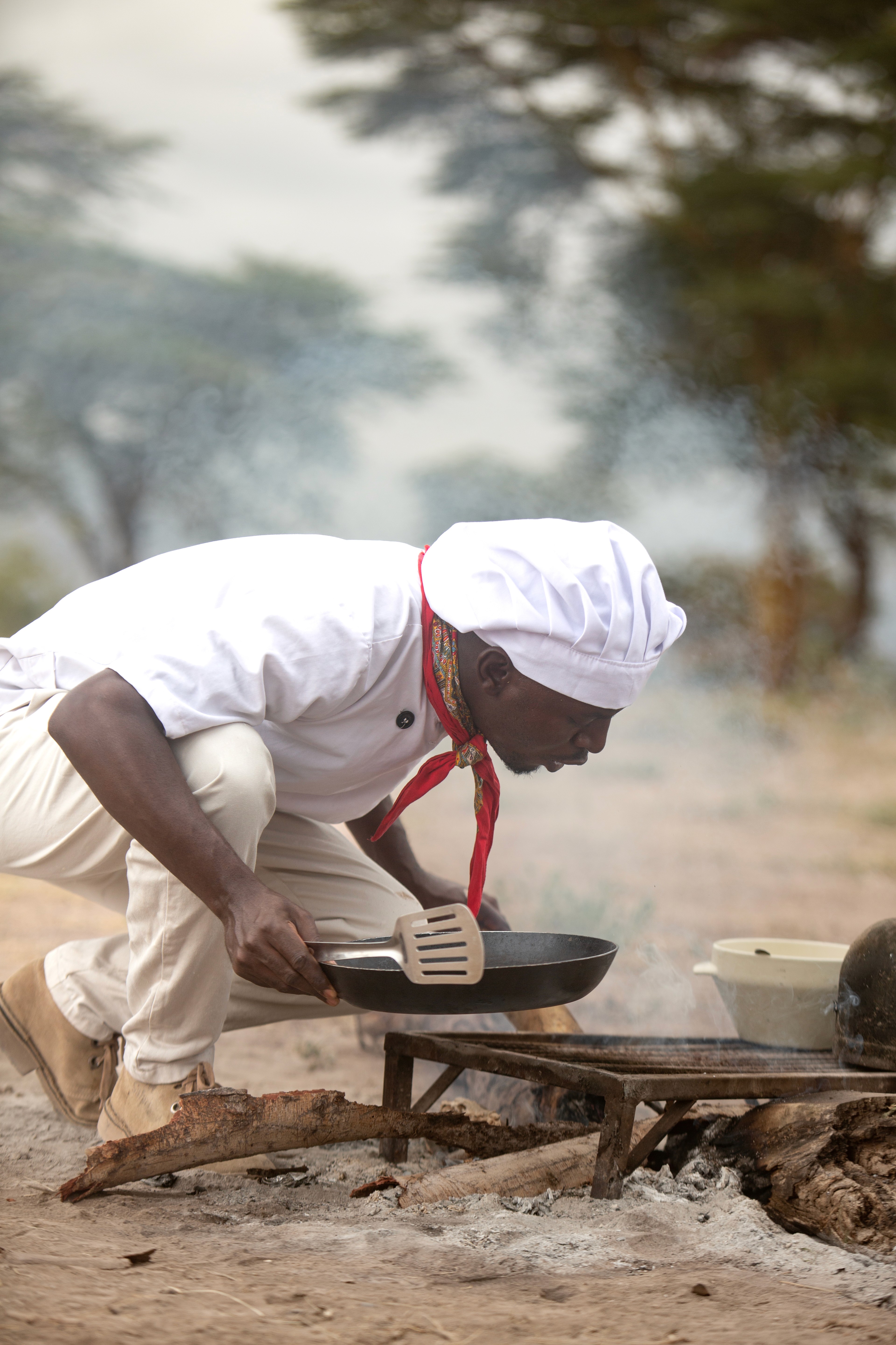 Kilimanjaro Elephant Ride, Arusha, Tanzania. En kvinna sitter och läser utanför ett tält uppsatt i vildmarken.