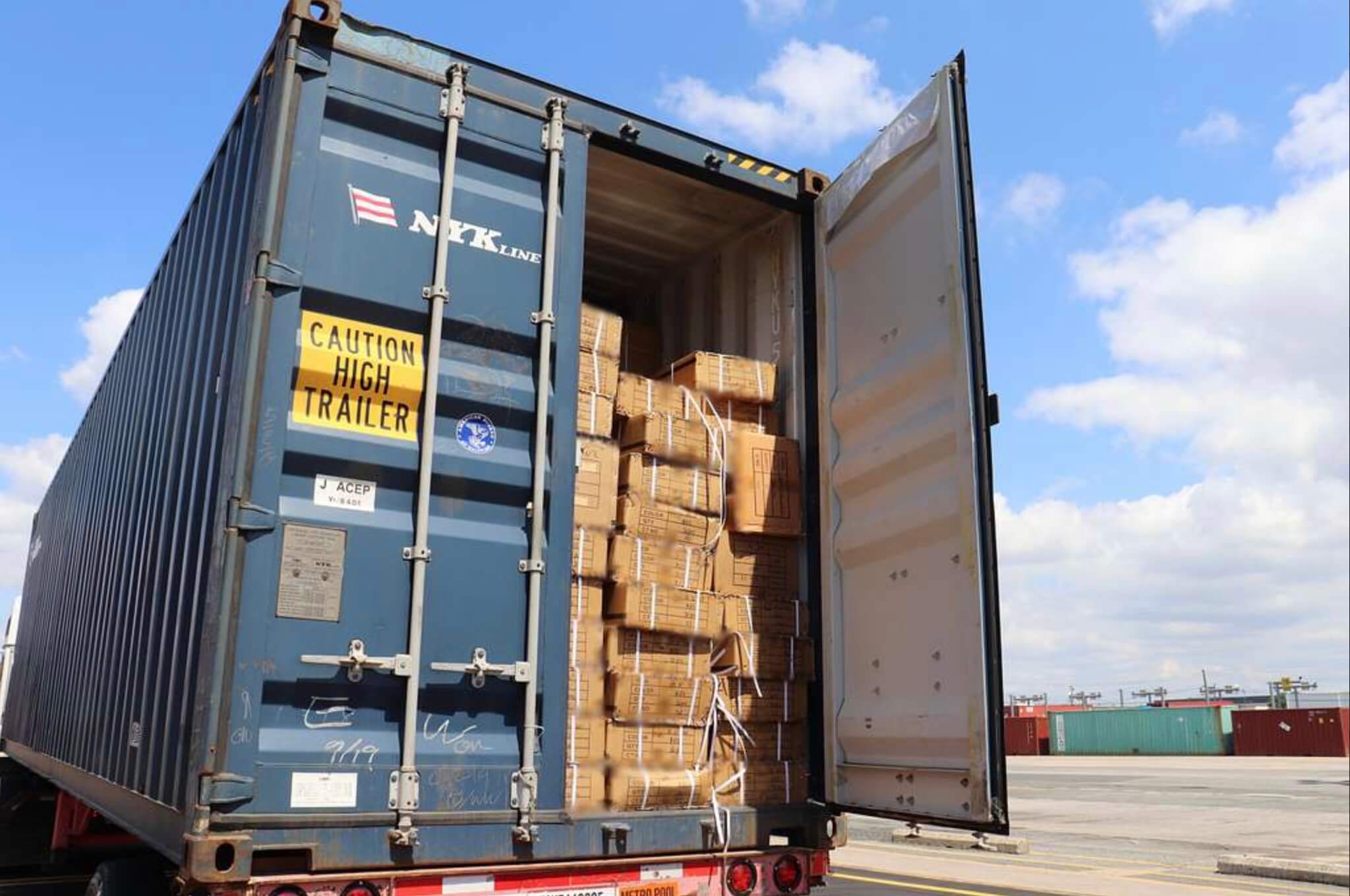 an open shipping container stacked with boxes inside