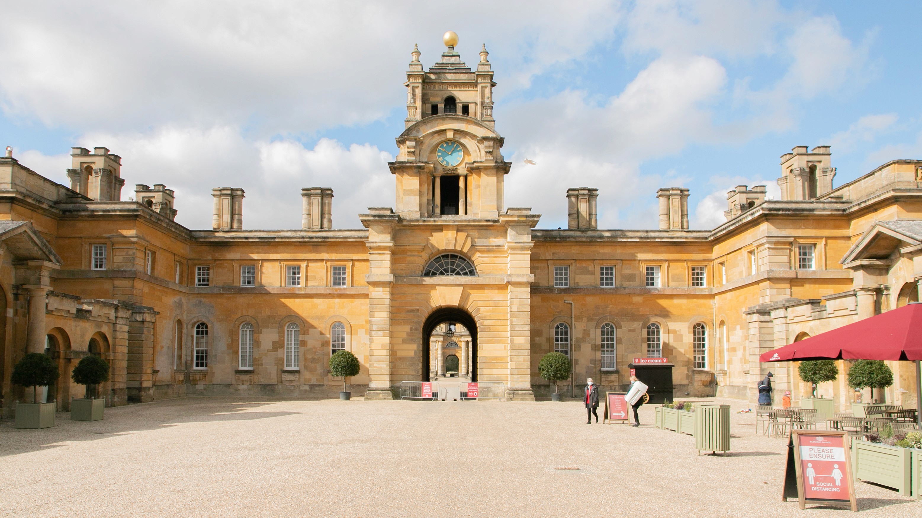 Two classic volkswagen beetles, one green, one cream.