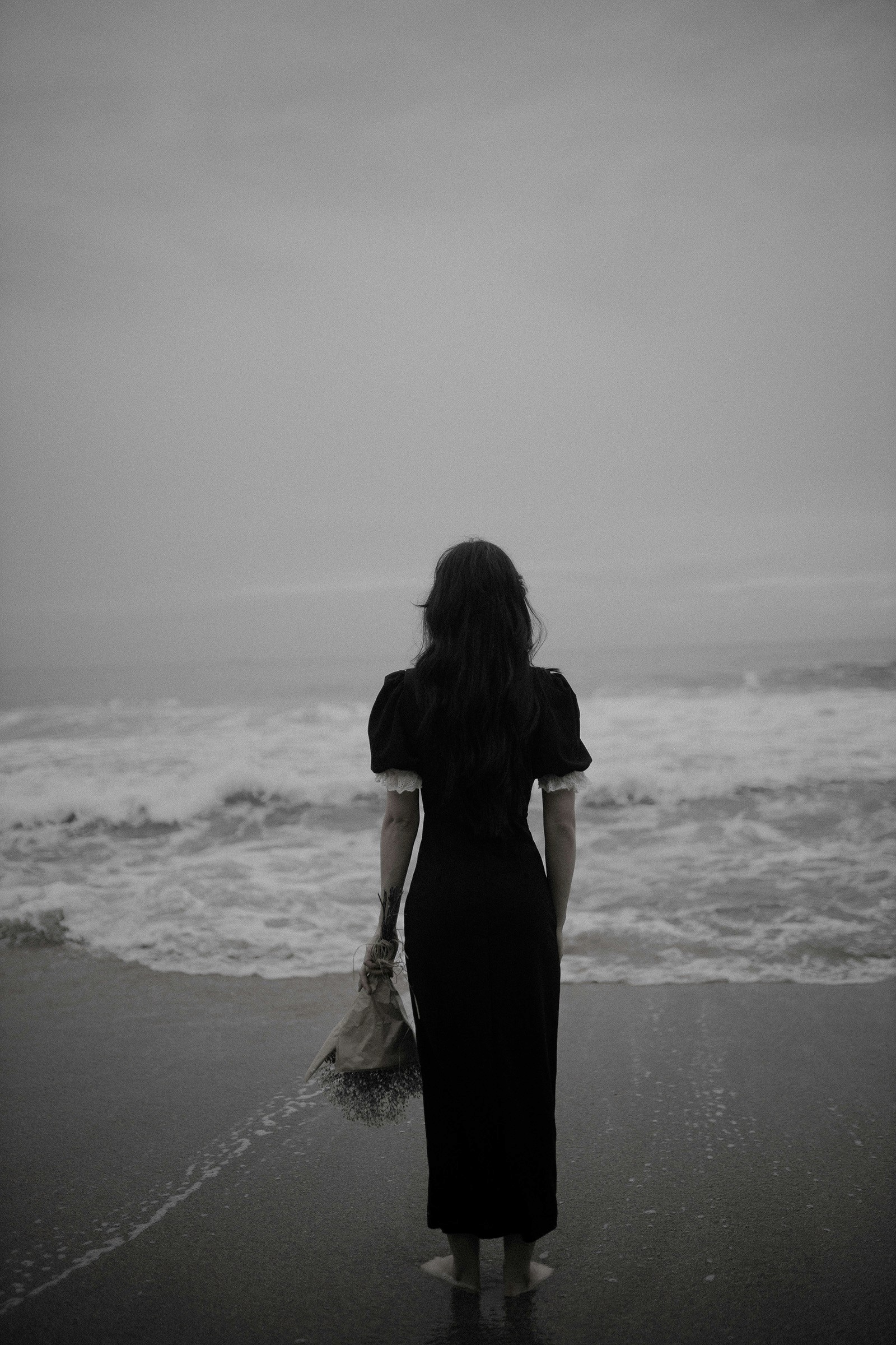Woman on the beach with a bouquet of flowers