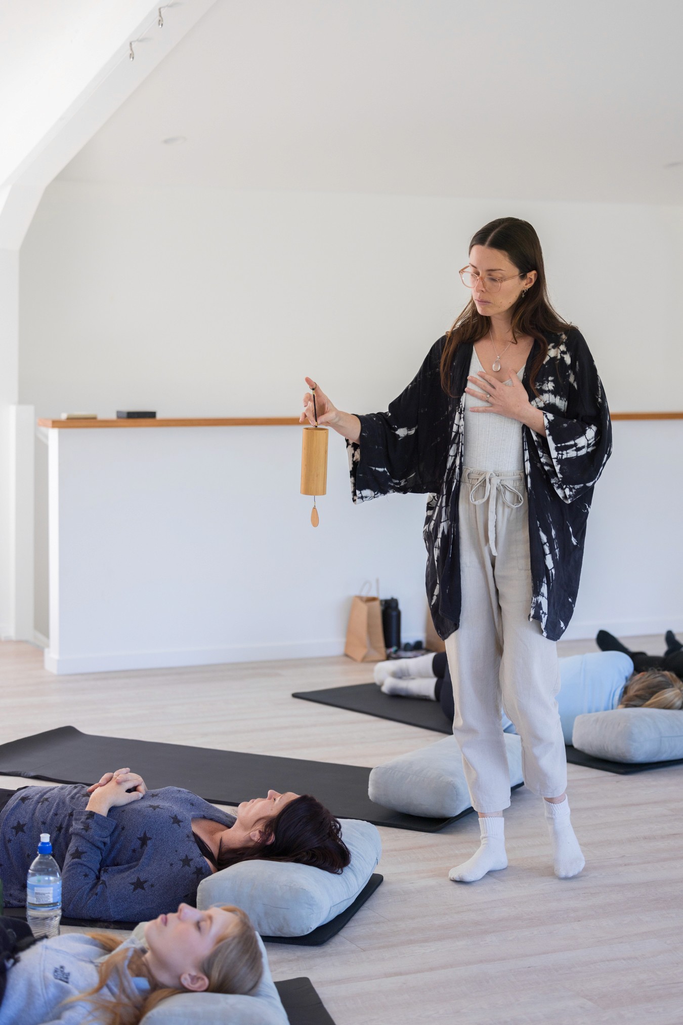Woman walking around meditation circle with wooden chime