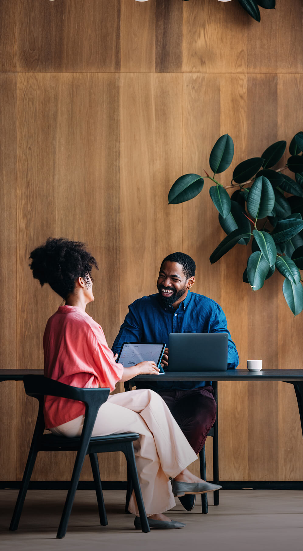 two people having a meeting in front of wooden wall