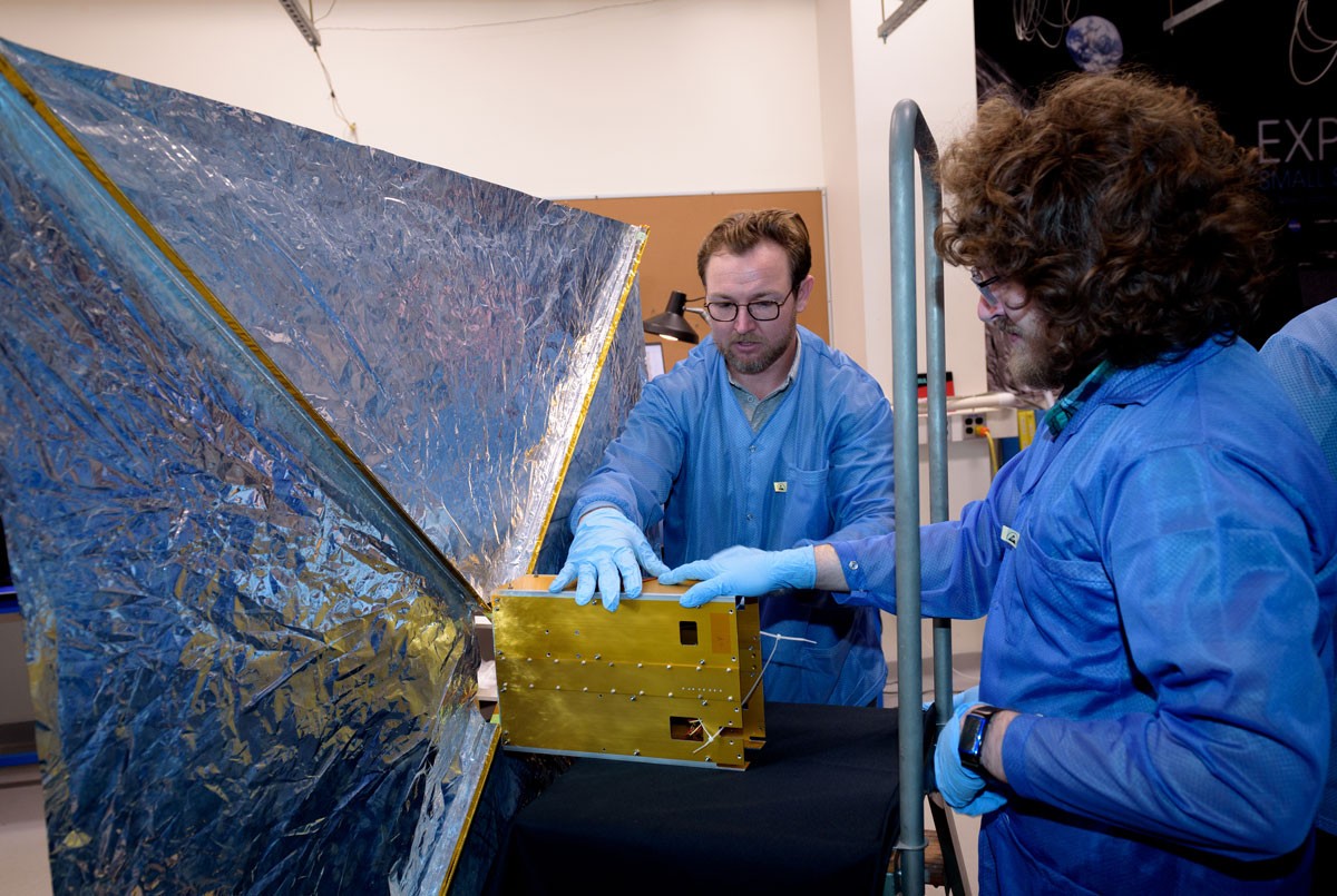 engineers inspecting the satellite