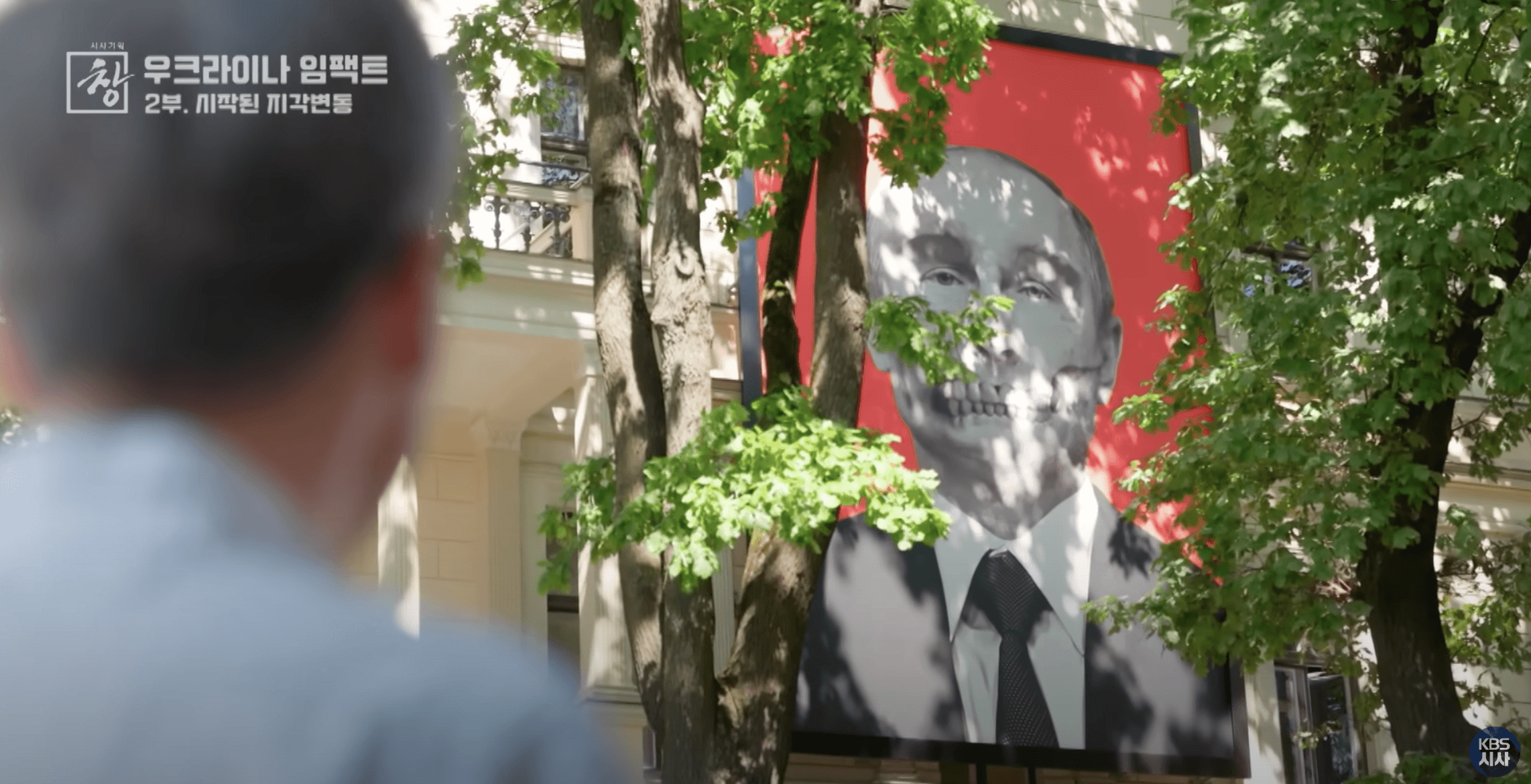 라트비아 리가 시내 거리에 설치된 대형 푸틴 러시아 대통령 조롱 포스터다. 붉은 배경에 푸틴의 흑백 초상화가 그려져 있으며, 시민들이 이를 바라보고 지나가고 있다. 러시아-우크라이나 전쟁 이후 발트 3국의 반러시아 정서를 상징적으로 보여주는 거리 설치물이다.