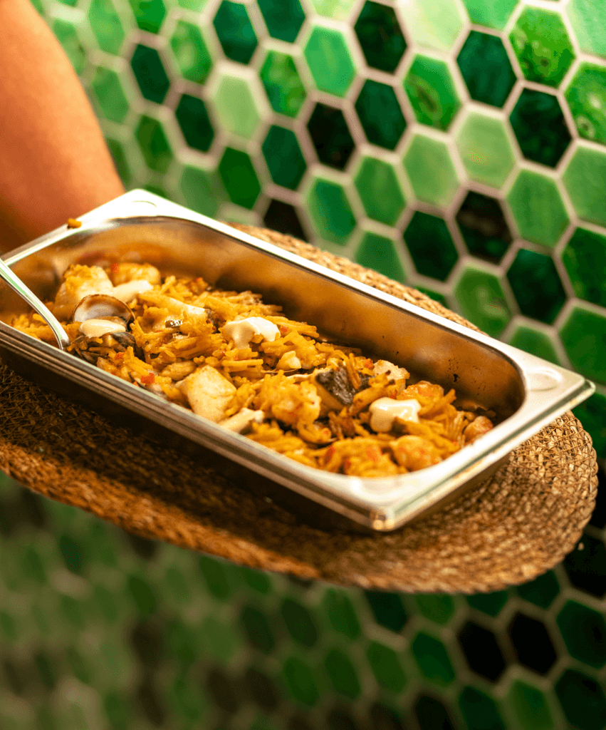 A woman lying on a massage bed, illuminated by soft sunlight streaming through a nearby window. A lush green plant in the background enhances the peaceful and rejuvenating ambiance.