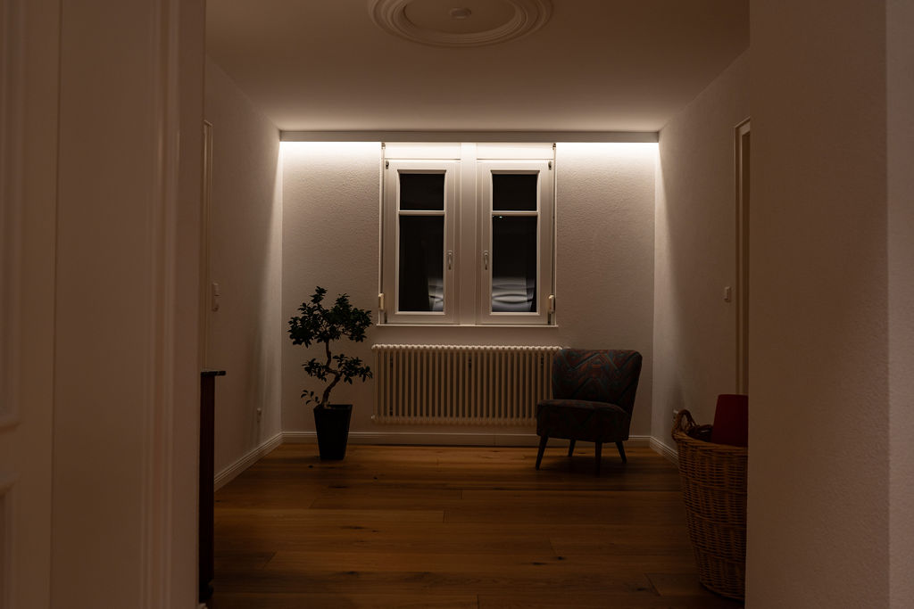 Modular wooden housing complex by the harbor, light snow falling, frozen water reflections.