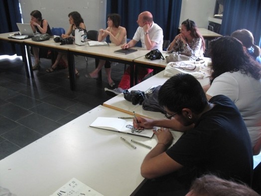 A photo of a group of students taking notes at alecture.