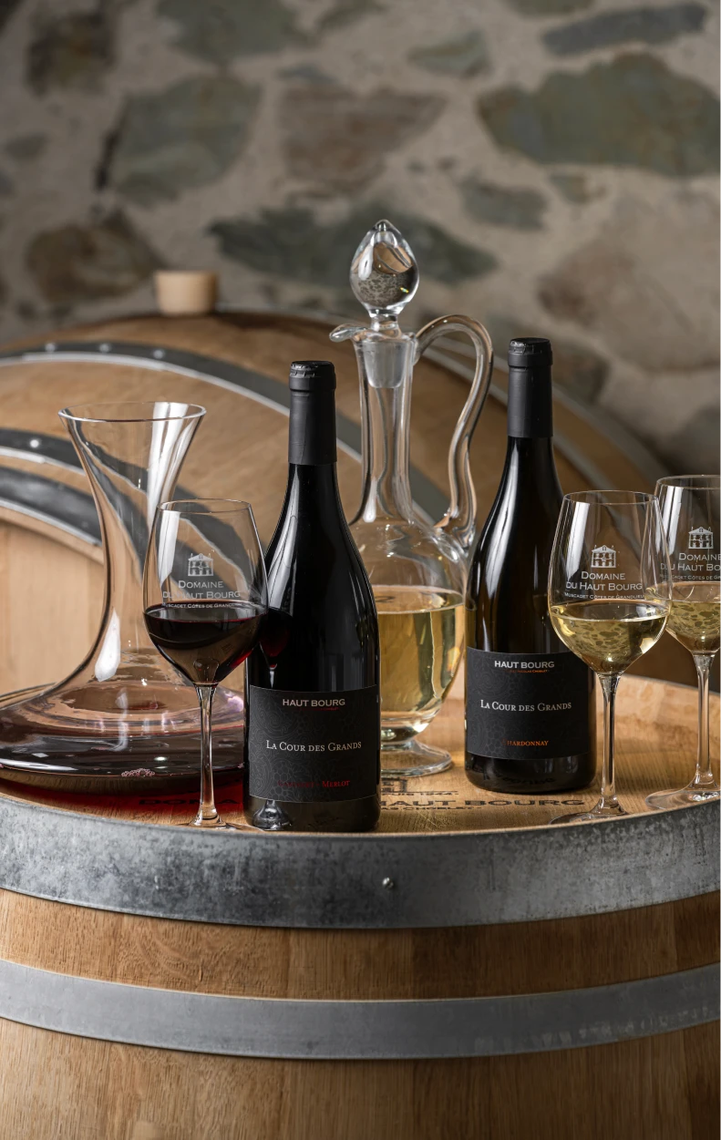 Cuvées La Cour des Grands, carafes et verres sur un fût de chêne