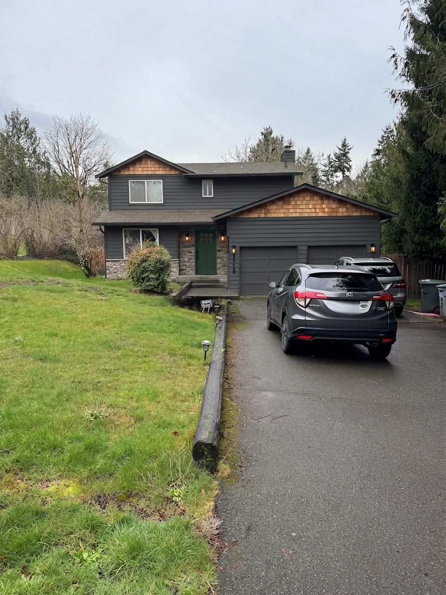 Charcoal siding with darker accent panels and forest green front door
