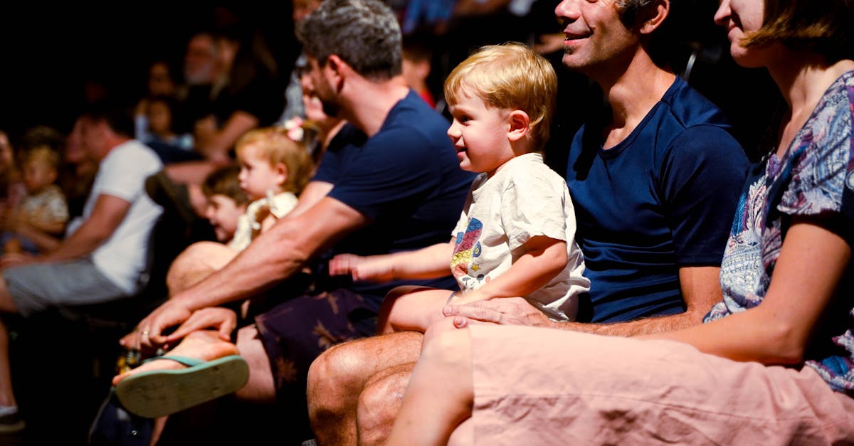 A diverse audience, including families, enjoys a live performance in a Brasil theater.