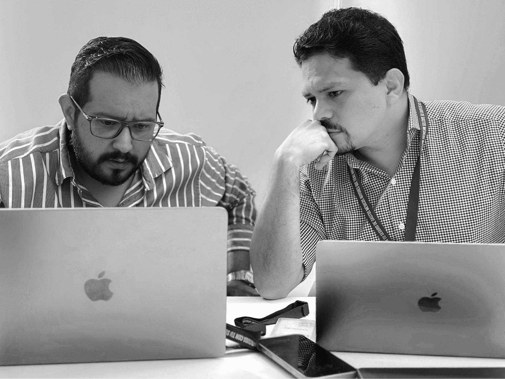 Juan Carlos y Alex observan y hablan mirando la pantalla de un laptop