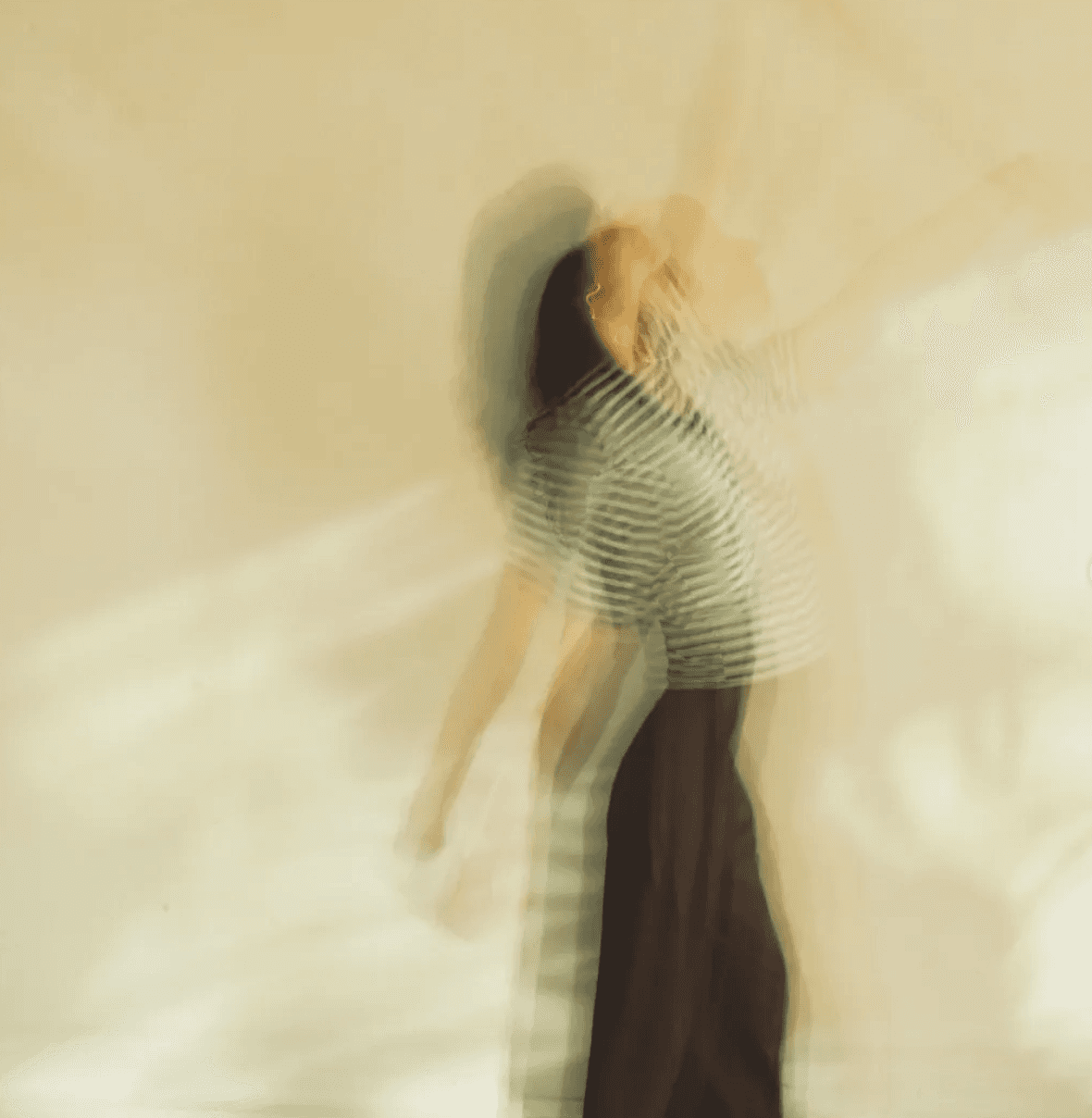 Blurred figure in striped shirt and dark pants.