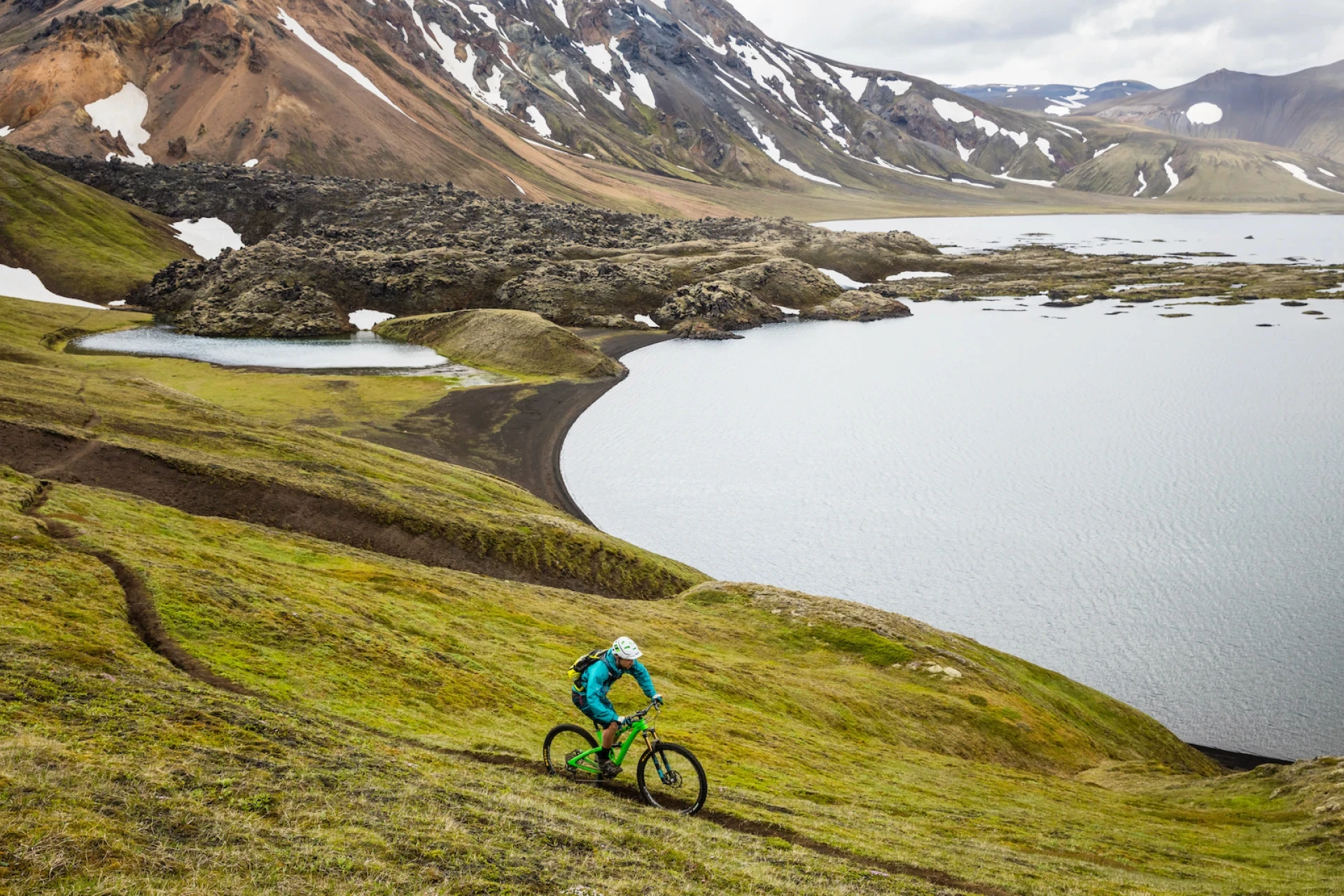 One rider rides mountain bike in a scenic location by a lake