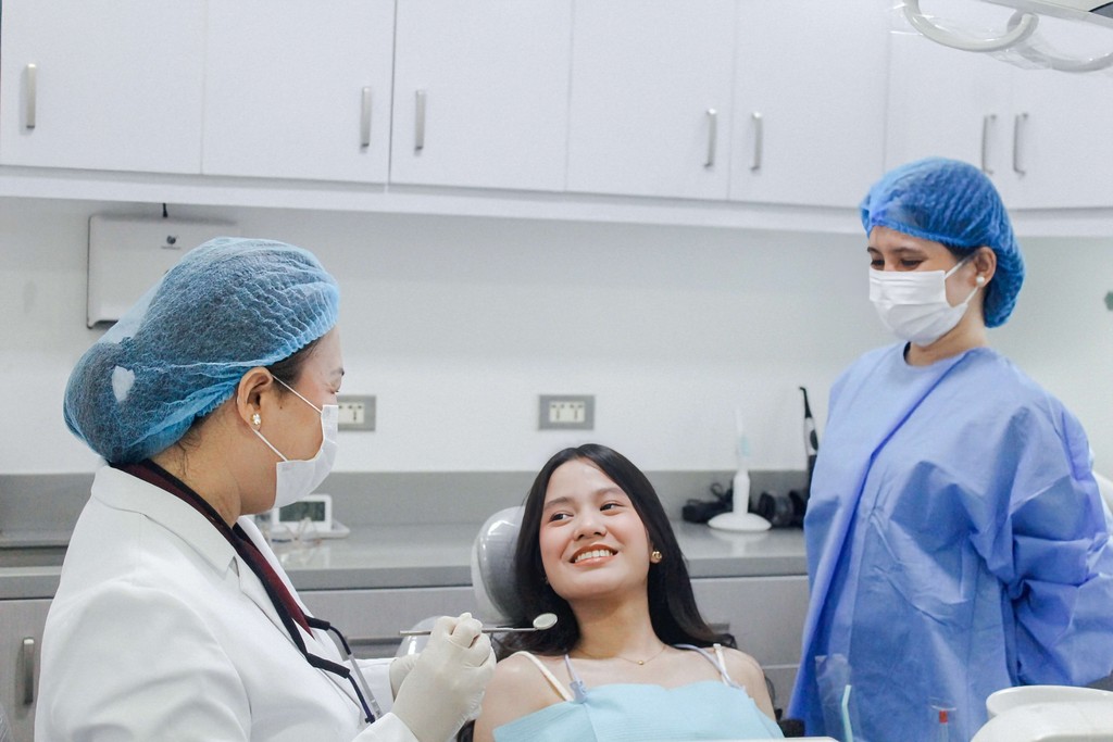 Image of clinic with Dr. Karleen with patient performing dental examination.