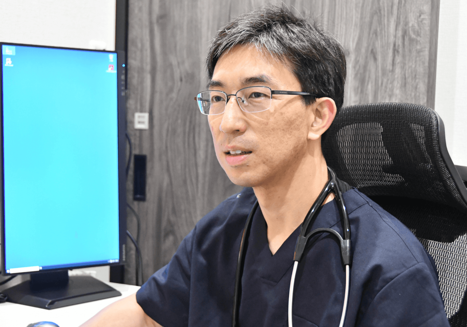 診察室でインタビューに応じる濵﨑秀崇先生
