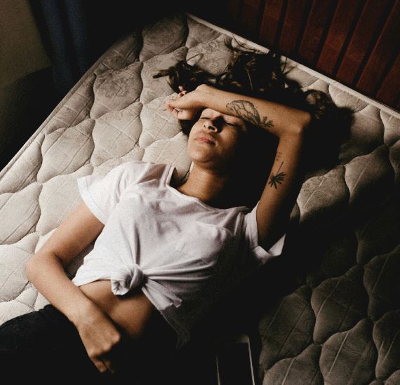 Ilustración de una persona con dolor de estómago causado por ansiedad, tocándose el abdomen.