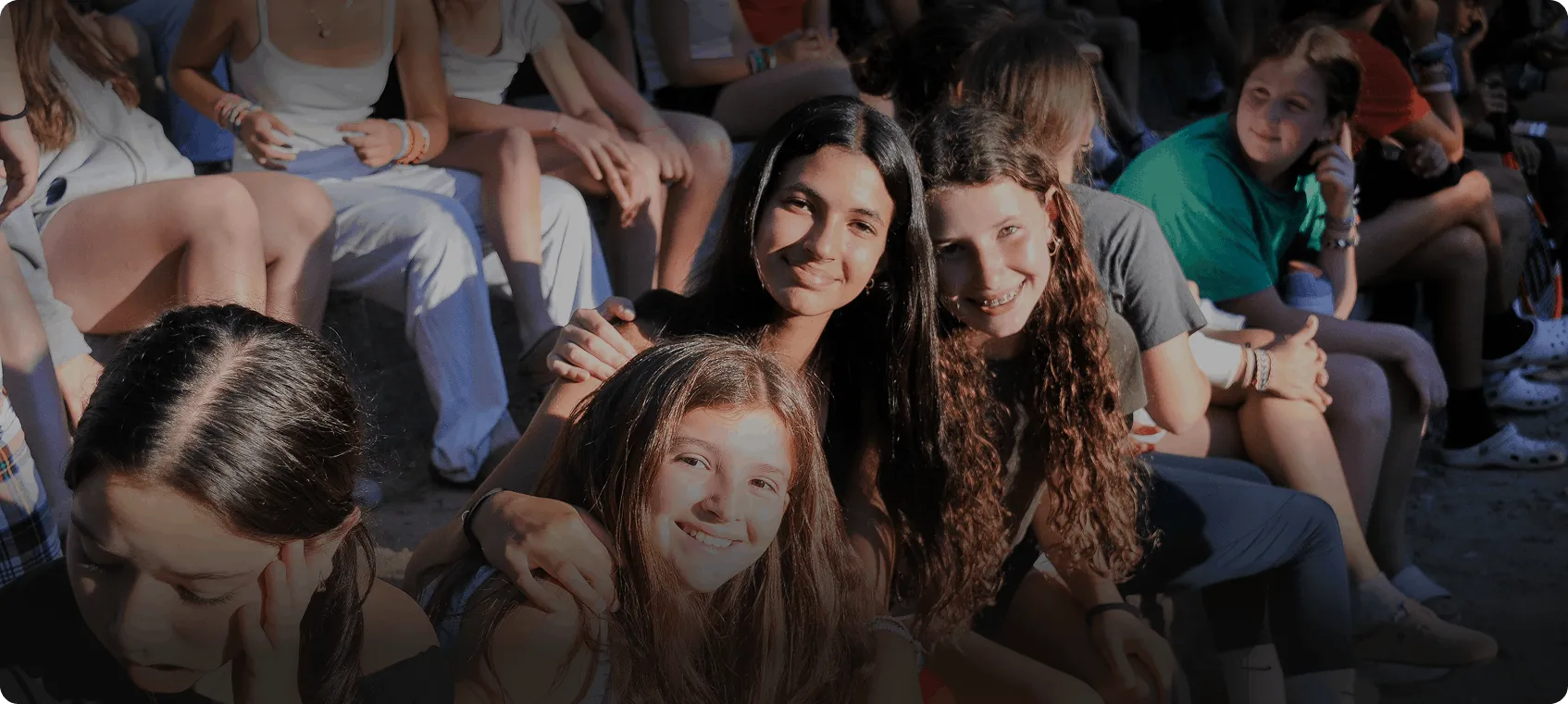 Smiling campers sitting together at Camp Lenox