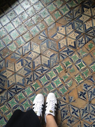 someone with sneakers on mosaic tiles