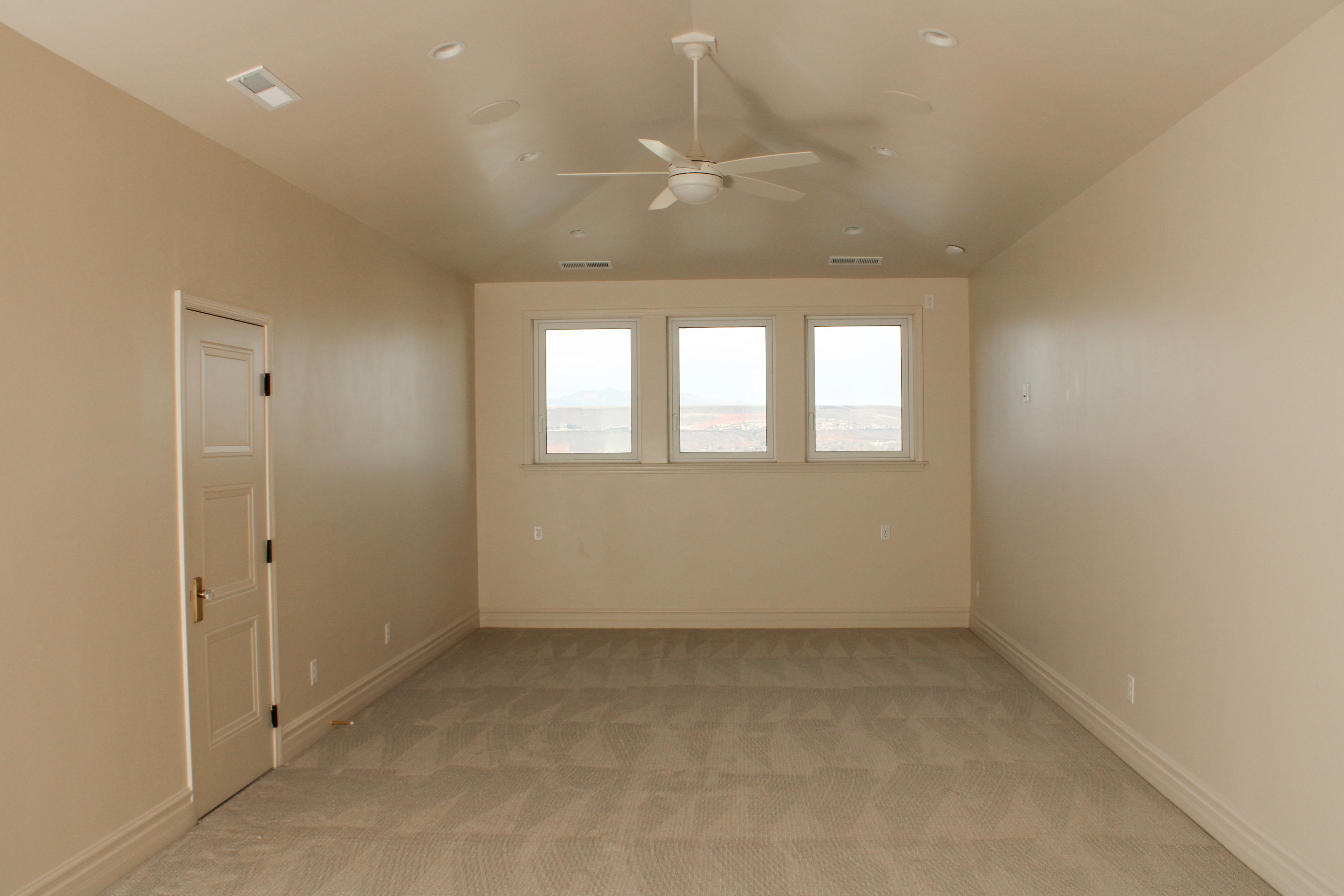 Large carpeted room with flexible layout in a custom home in St. George, Utah.