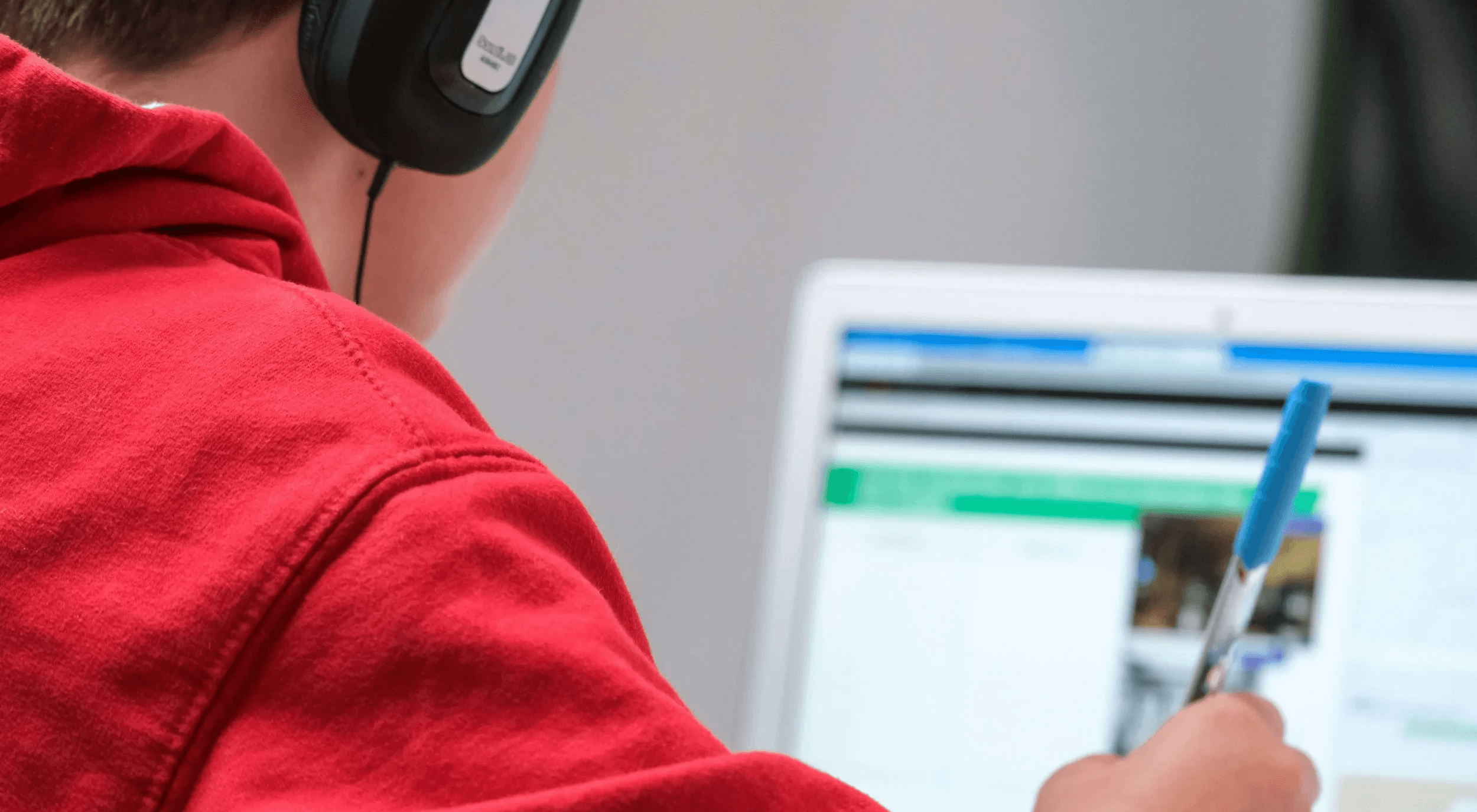  Boy wearing headphones studying on laptop - Best French Courses Online 
