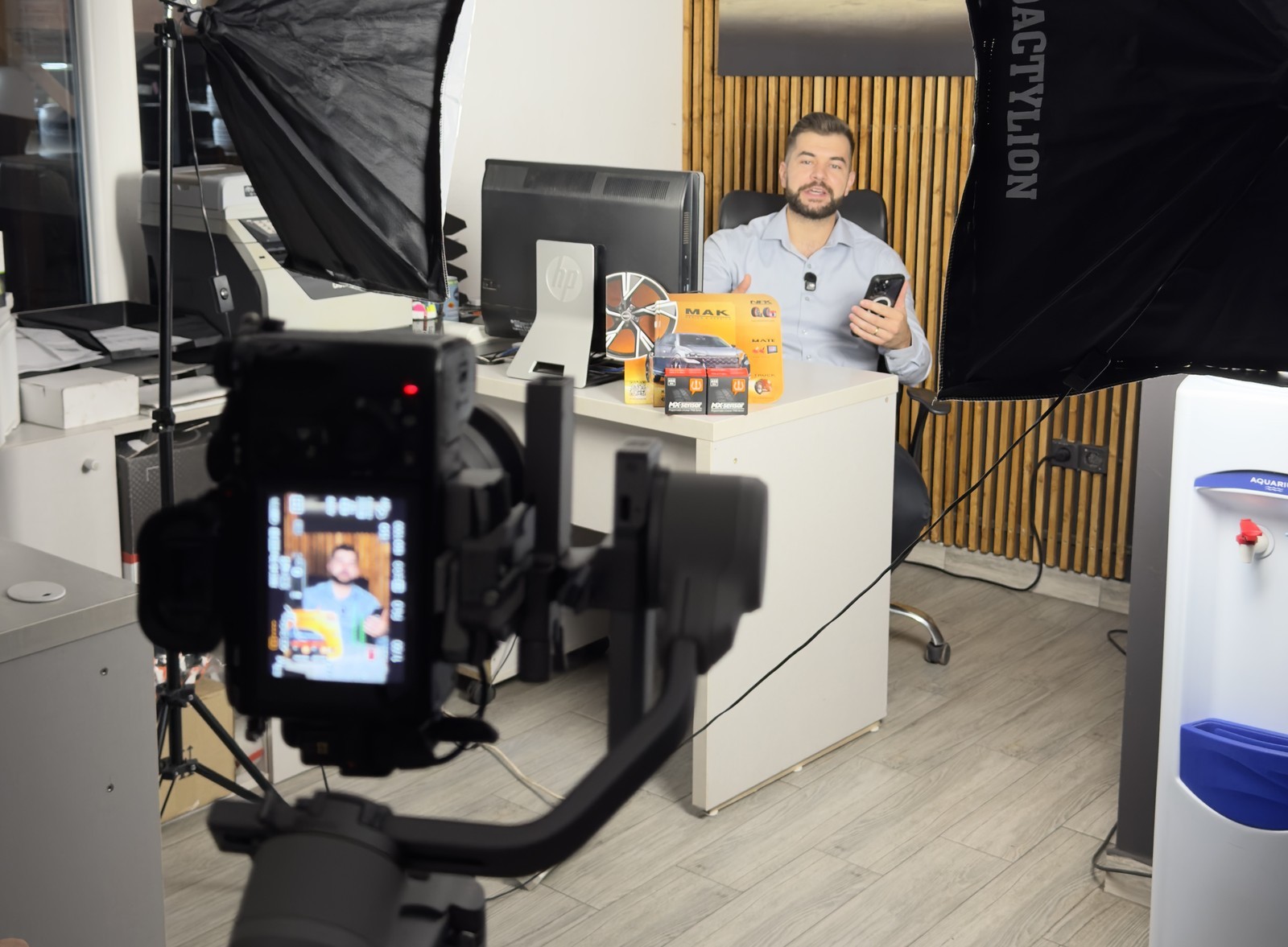 Filmare la sediul unui client: cameră pe stabilizator, lumini de studio și prezentatorul la birou