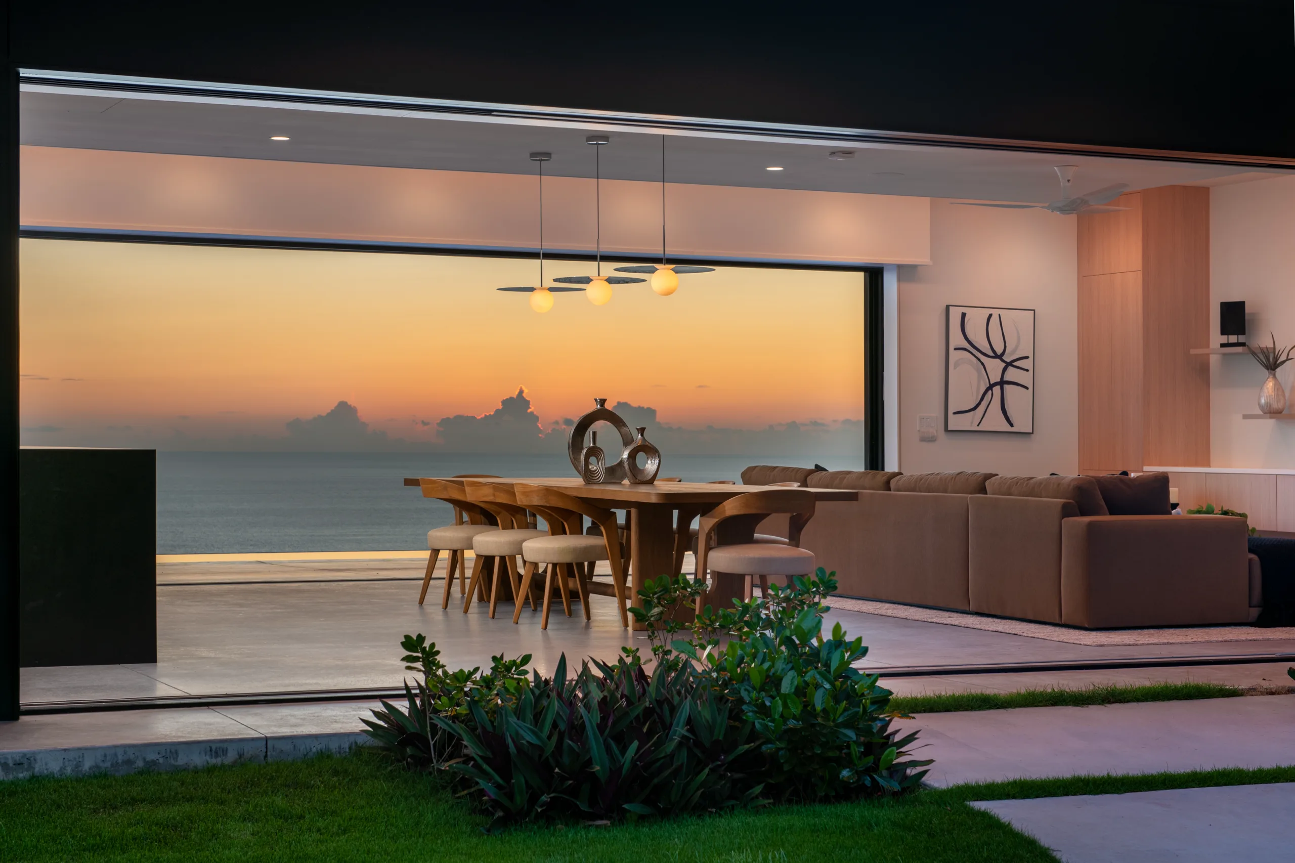 Living room opening to the ocean at sunset, Nāpōʻopoʻo Hale, South Kona