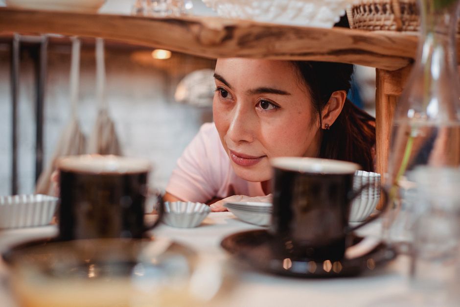 A pensive person sitting in a home kitchen near comfort food, reflecting on the emotional loss of food as comfort while taking a GLP-1 medication