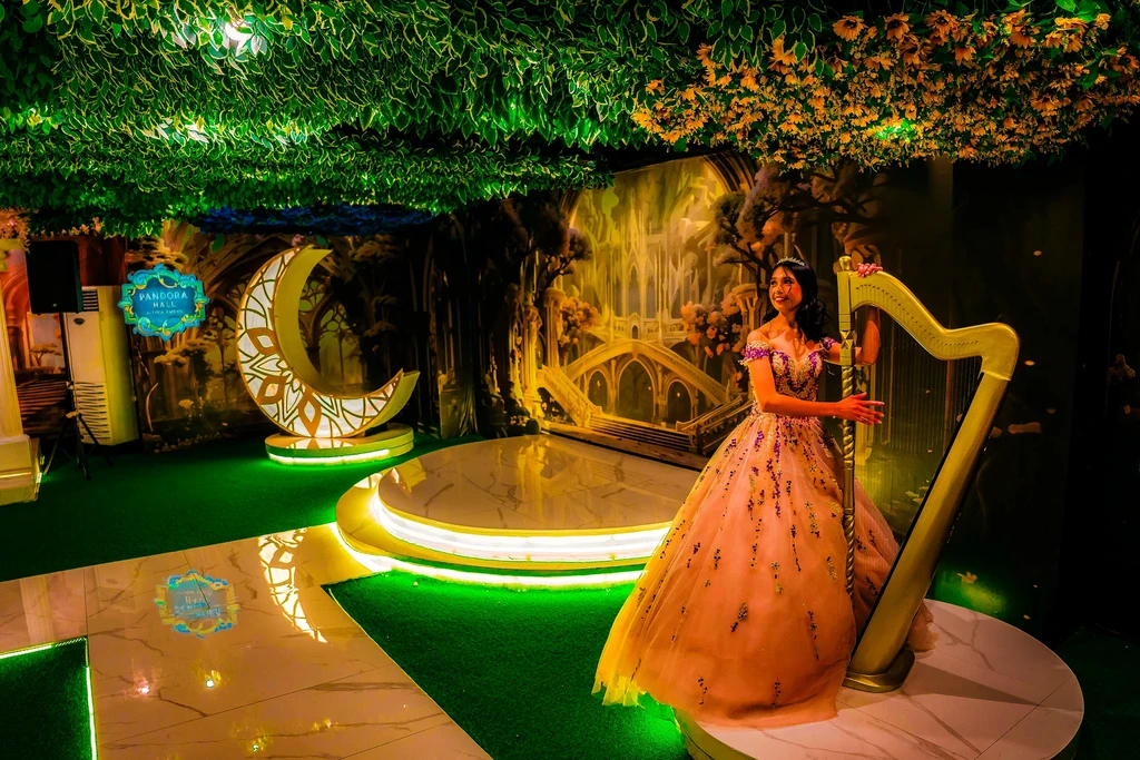 Debutante in peach playing the golden harp at Pandora Hall, Stalla Suites QC