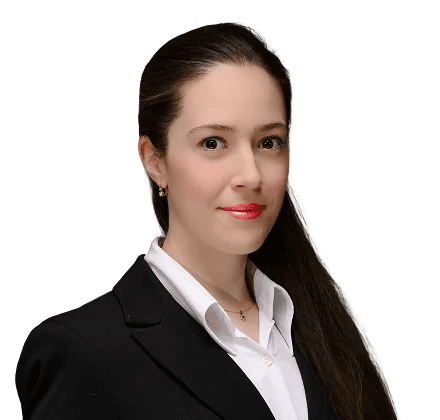 Női portré üzleti öltözetben, kék háttérrel, előrenéző testtartással.