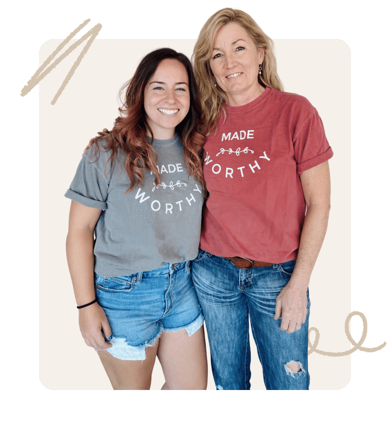 Two women smiling and standing close together, wearing matching "Made Worthy" t-shirts. One is wearing a gray shirt and the other a rust colored shirt.