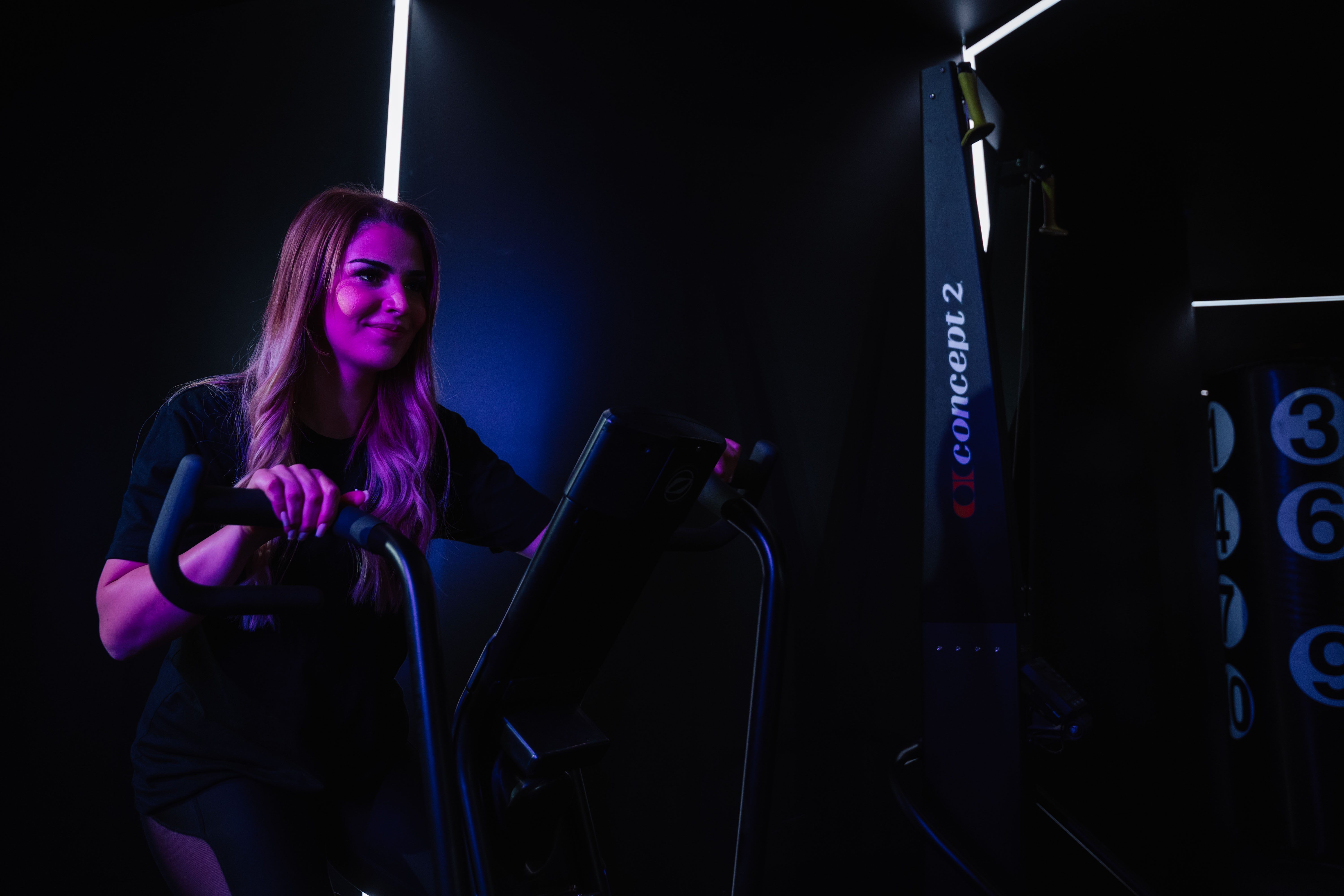 Rachel, personal trainer, looking to the side confidently in a fitness studio