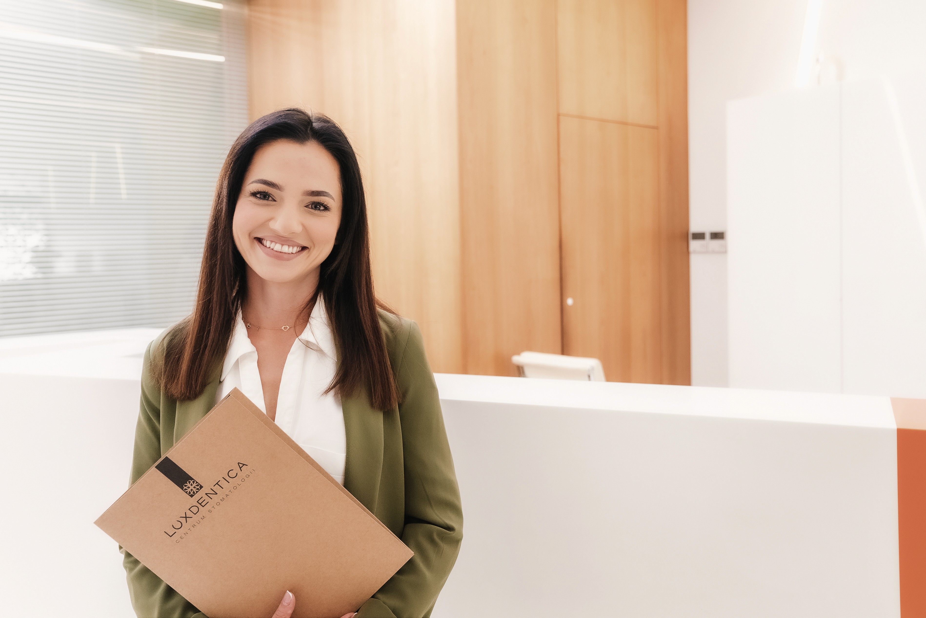 Opiekunka pacjenta uśmiechająca się do kamery