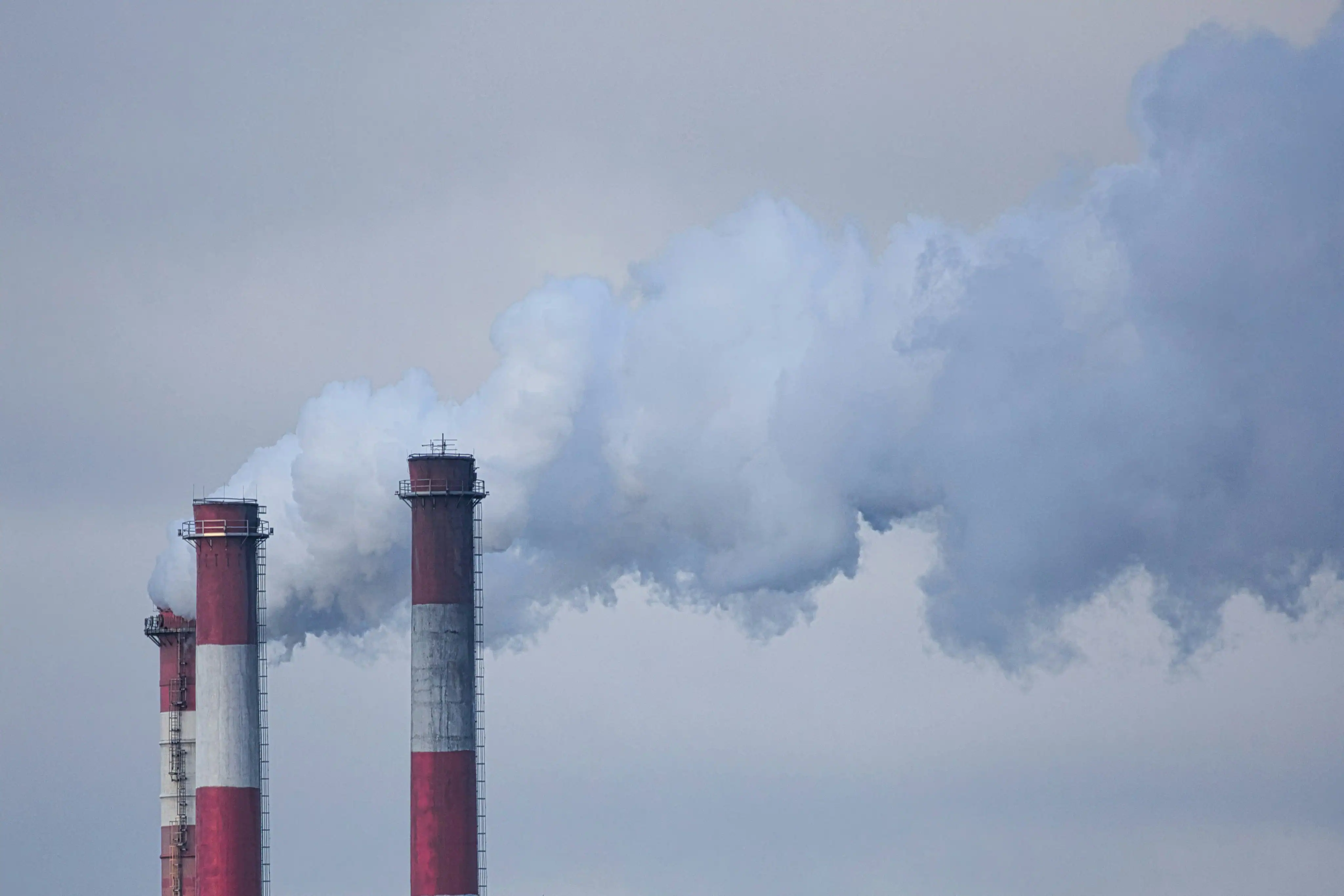 Industrieschornsteine mit Dampfemissionen – Symbol für Scope-1-Emissionen und CBAM-Berichterstattung in der Industrie