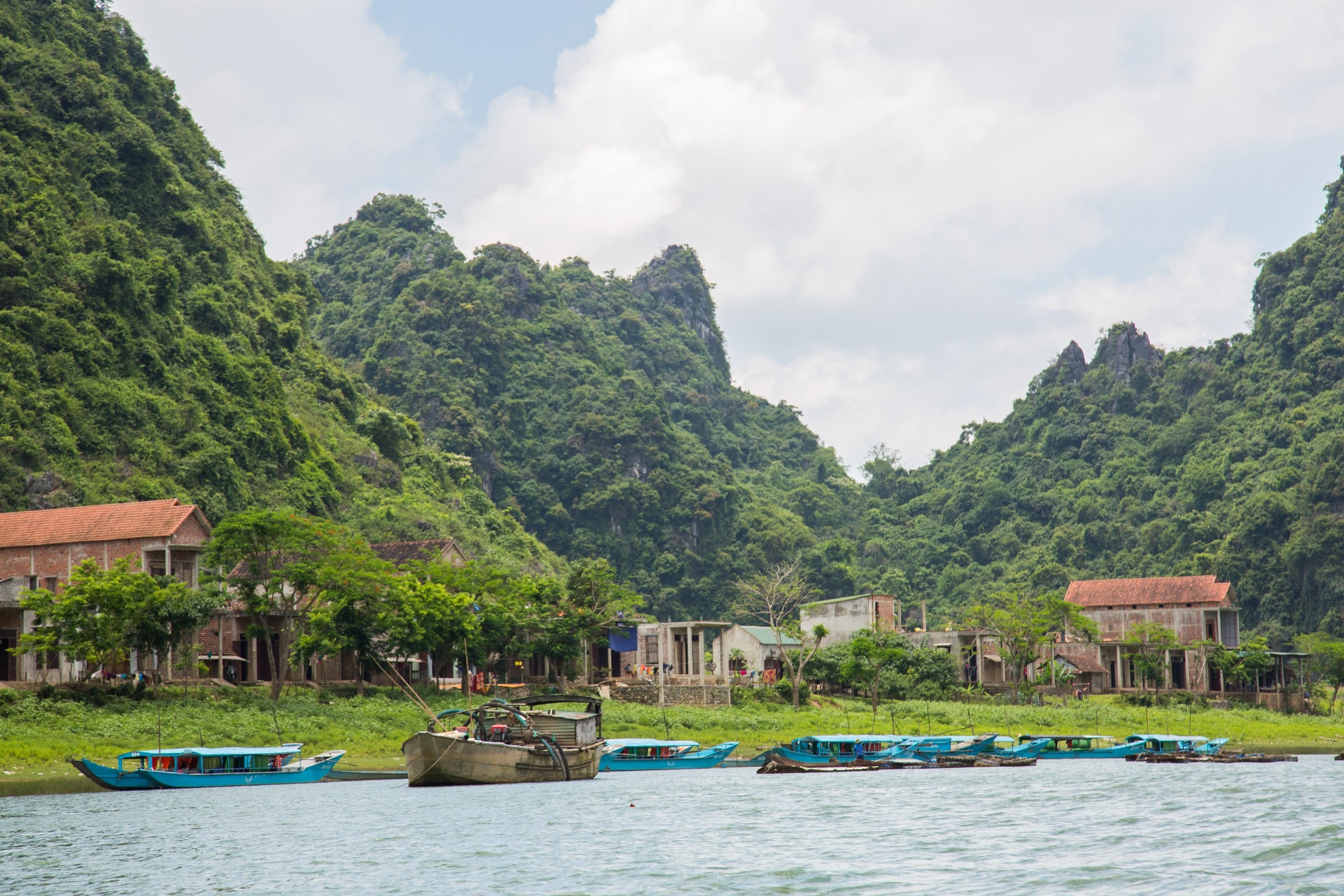 TRAVEL · Boats beneath limestone peaks.