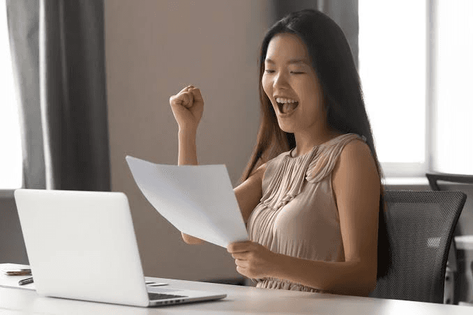 High school student reviewing published research paper alongside college acceptance statistics and university application materials
