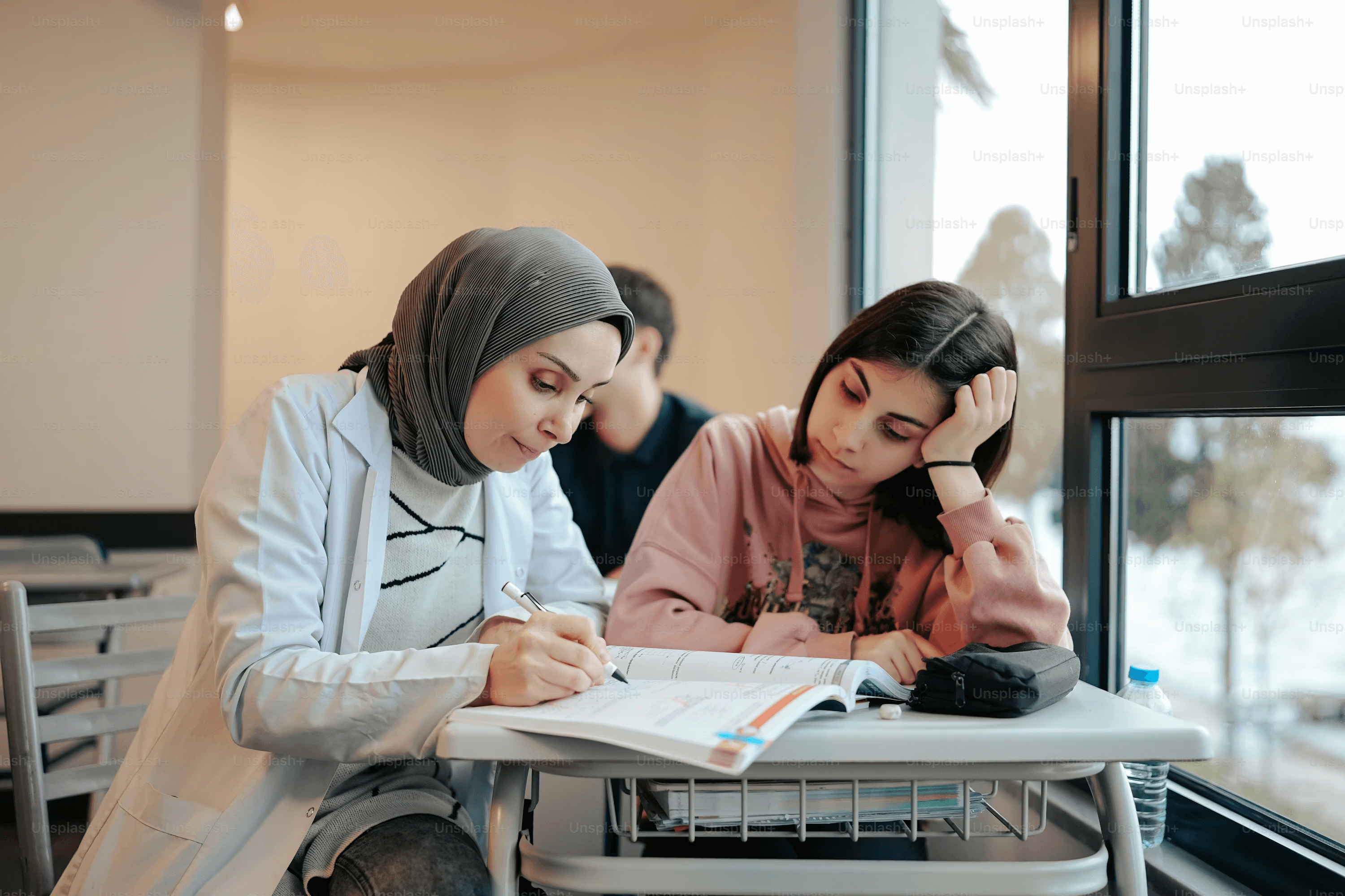 A Grade 12 student working on original research with a PhD mentor, reviewing academic papers at a desk