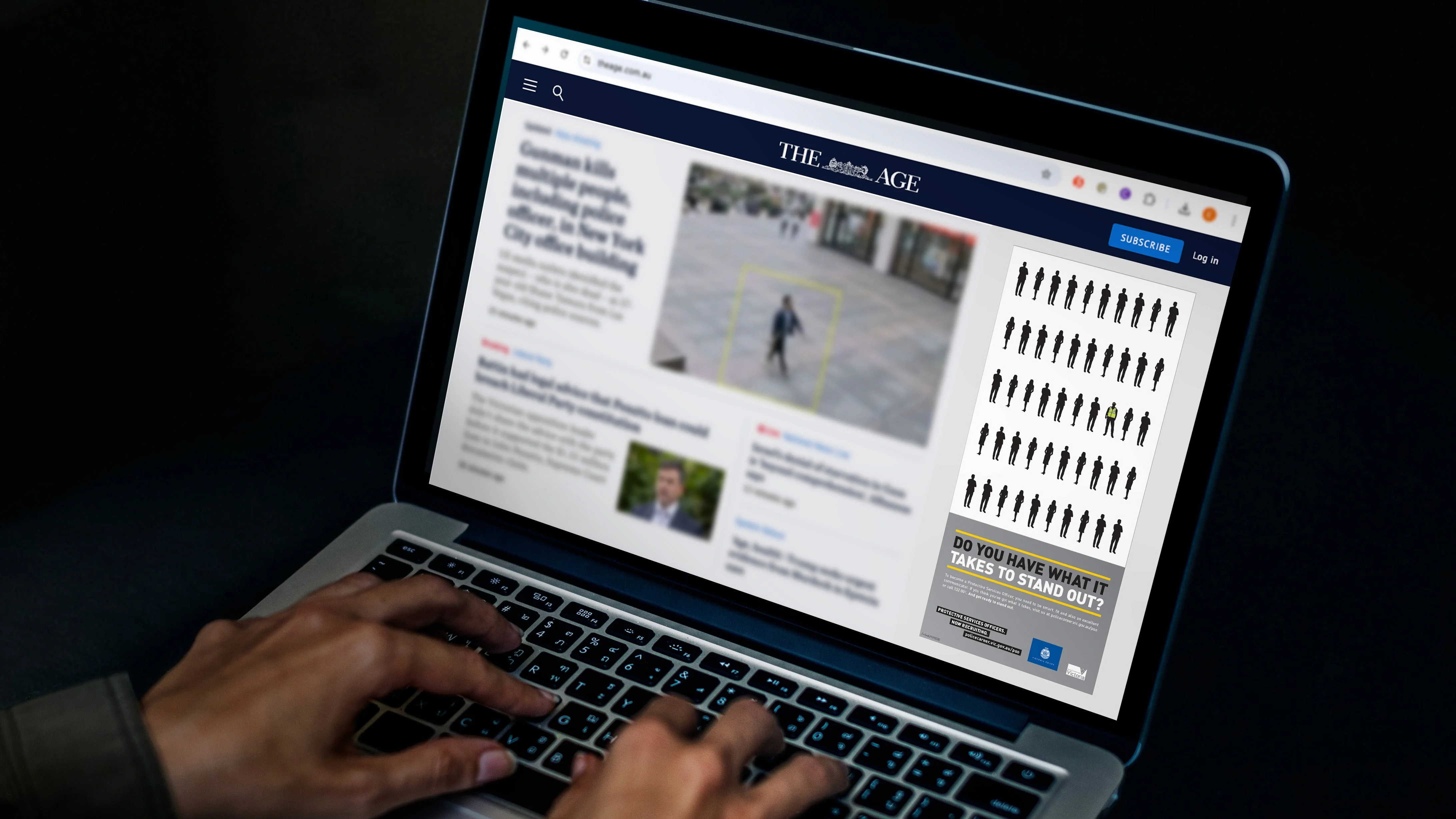 Laptop showing The Age website with a Victoria Police banner: 'Do you have what it takes to stand out?'
