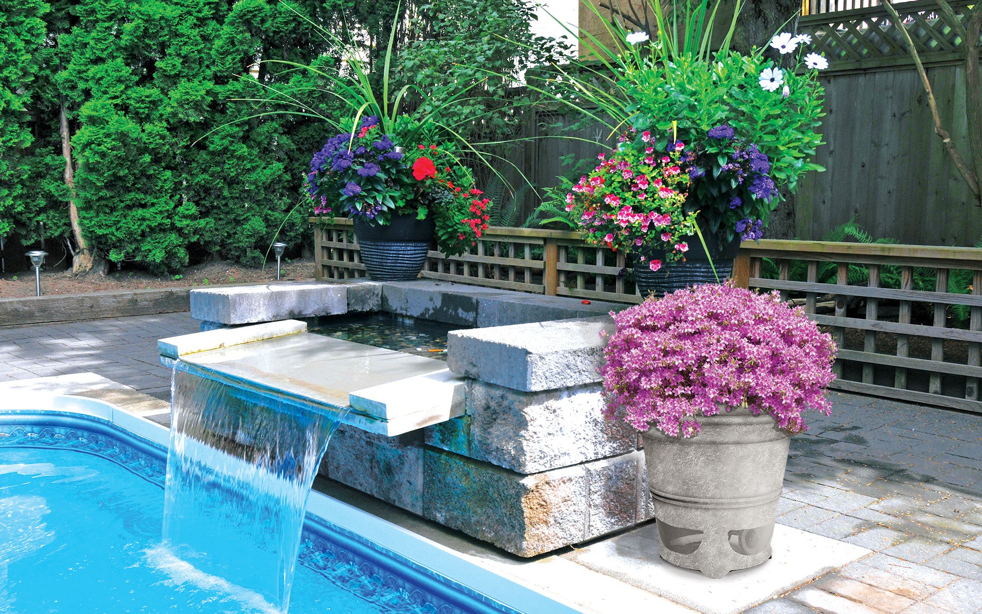 Poolside water feature with potted flowers and lush greenery.