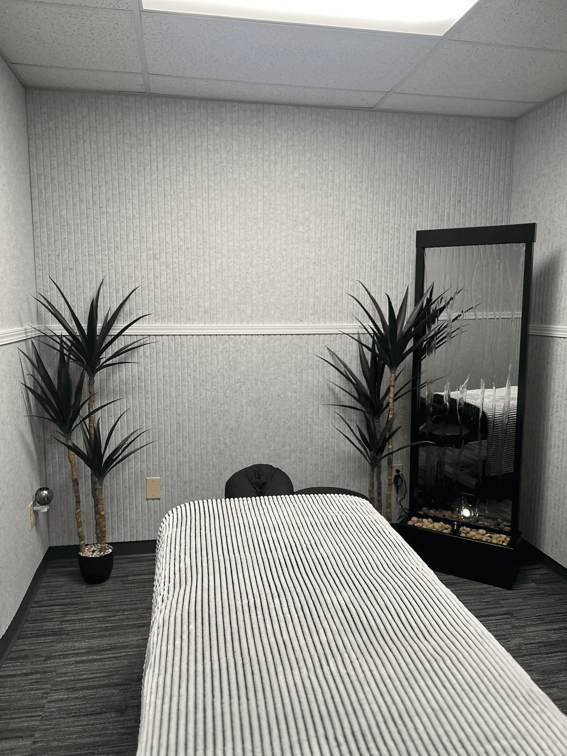 Private, modern physical therapy treatment room at Advantage Physical Therapy featuring a black examination table and specialized clinical equipment.